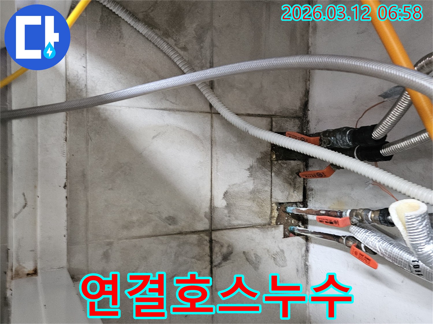 유연한-연결-호스-주변에서-발견된-물-자국과-습기를-확인하며-미세한-누수-지점을-정밀-보수하는-모습