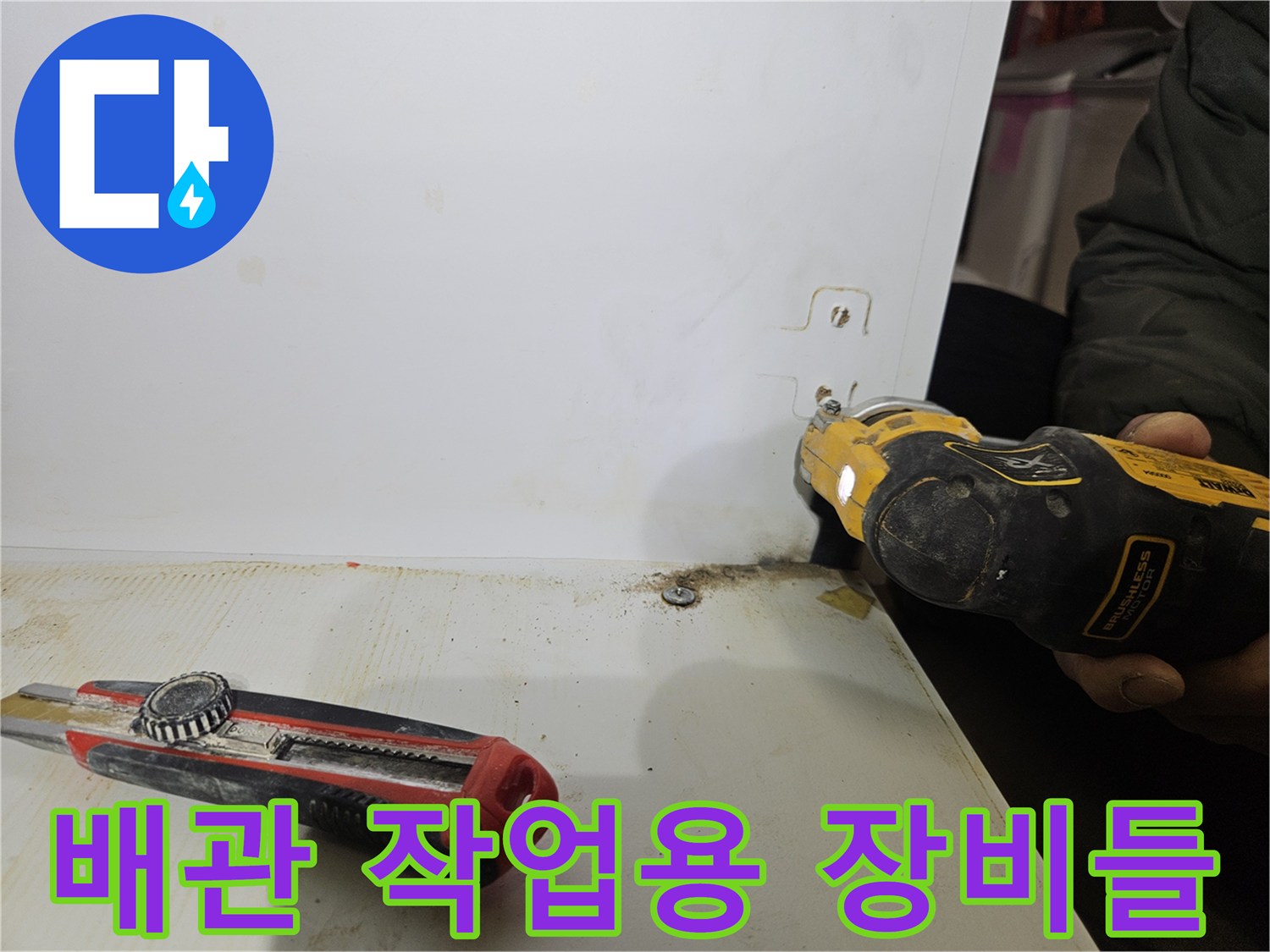 현장 바닥에 놓인 전동드릴과 커터칼의 근접 사진