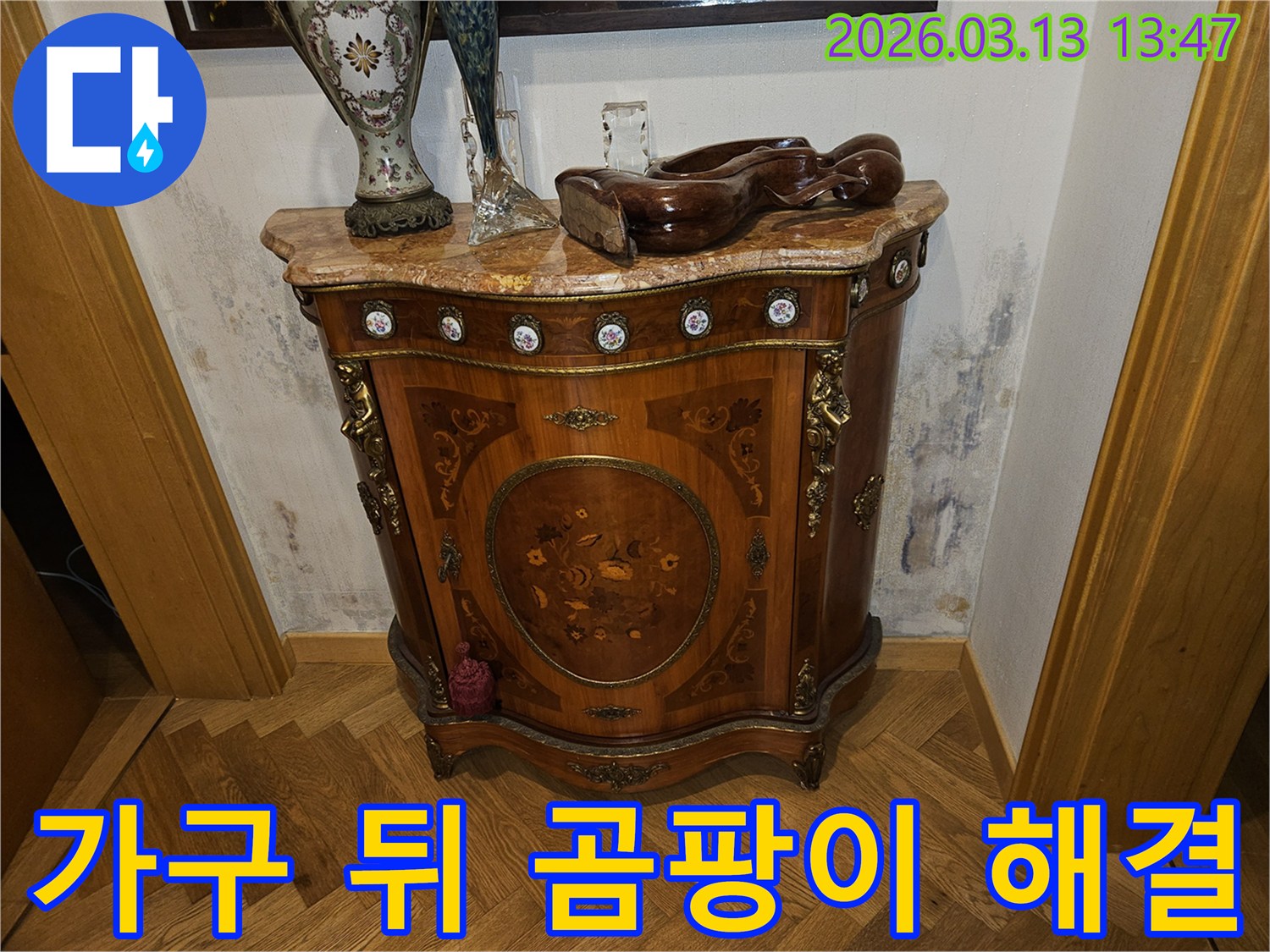 고급스러운 콘솔 가구 뒤-벽에 발생한-누수로 인한-벽지 변색과-곰팡이 흔적을 보여주는 사진