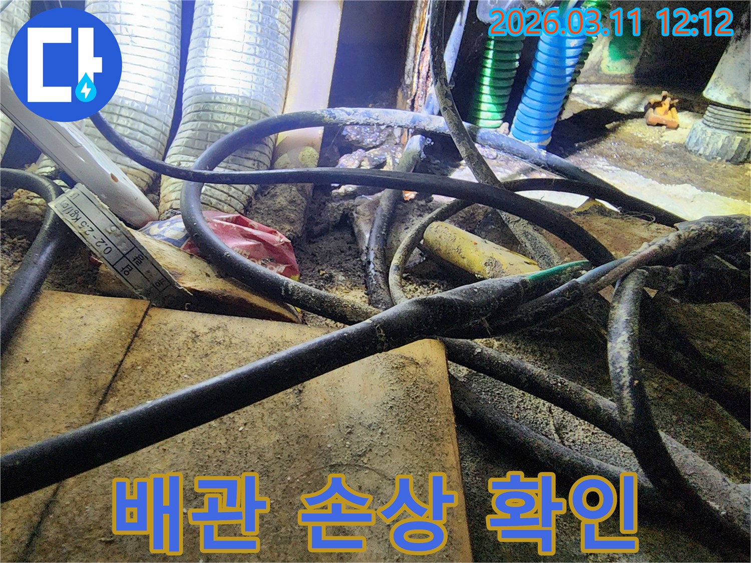 누수-현장에서-복잡하게-얽힌-배관들-사이로-손상된-배관의-흔적을-확인하는-모습을-보여주는-사진입니다.
