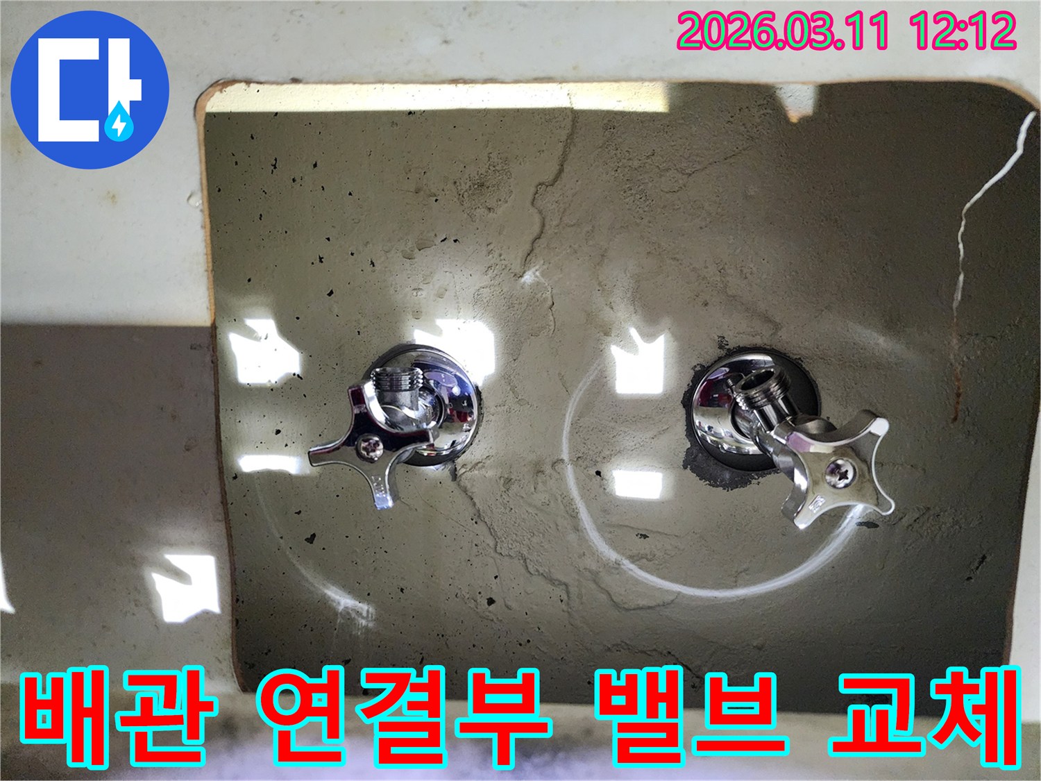 벽에-새롭게-설치된-두-개의-크롬-수도-밸브-핸들이-배관-연결부의-누수를-해결했음을-보여줍니다
