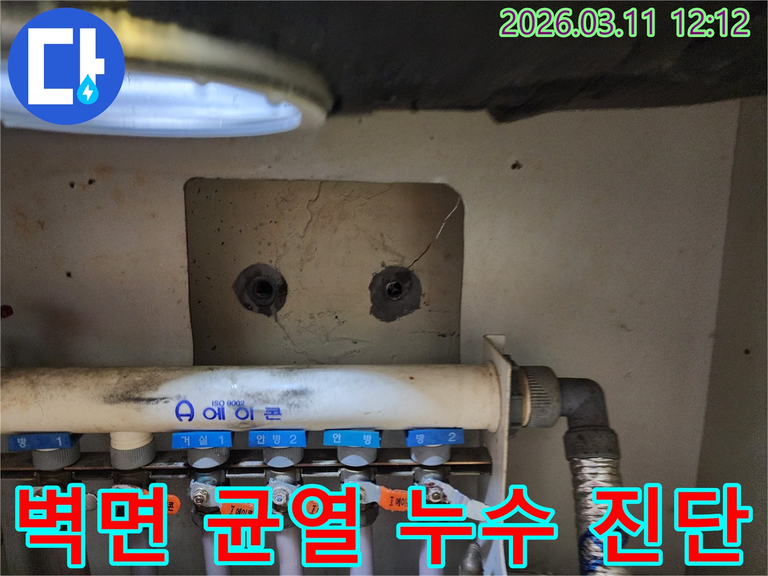 보일러 분배기 상단 벽면에-발견된 미세한-균열을-정밀하게 진단하는-누수 전문가의-모습