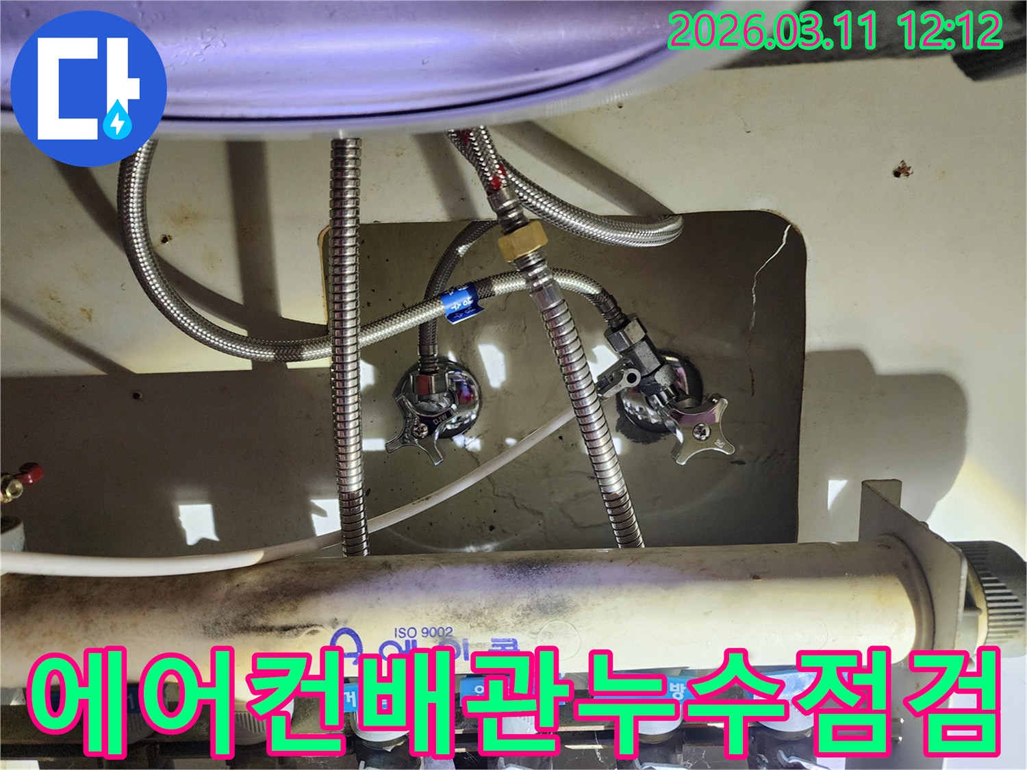 숙련된-엔지니어가-복잡한-수도-배관-연결부위의-누수-여부를-확인하는-장면