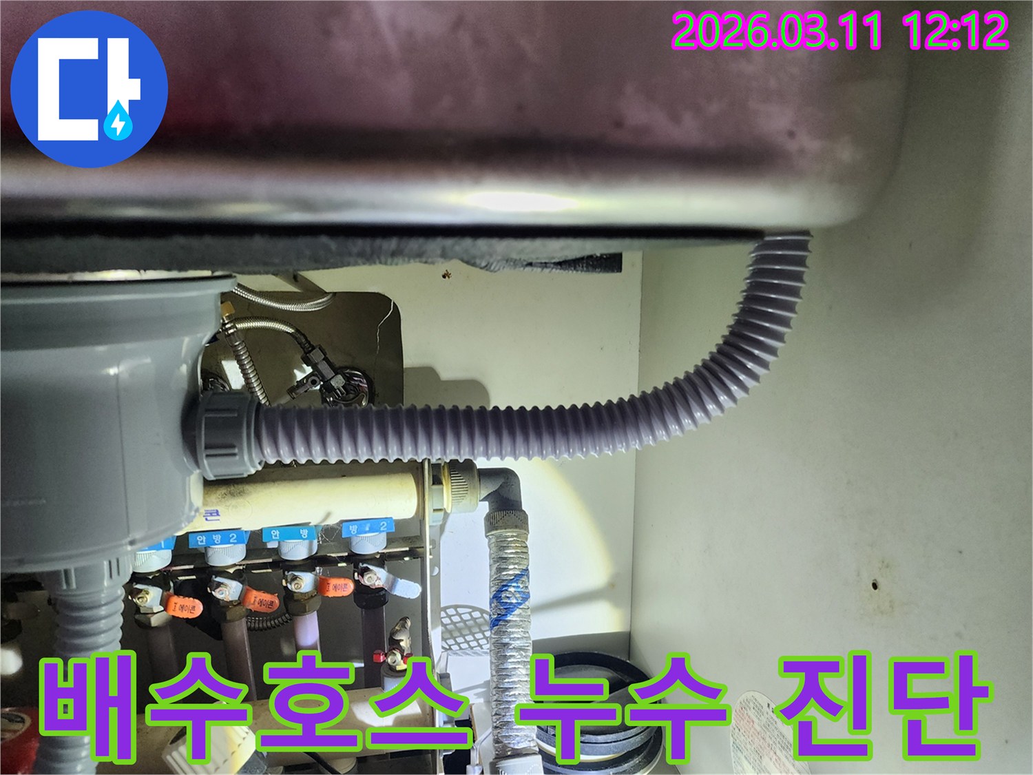 싱크대 아래쪽에서-배수 호스의 상태를-확인하며-누수 흔적을 찾는-작업 사진입니다
