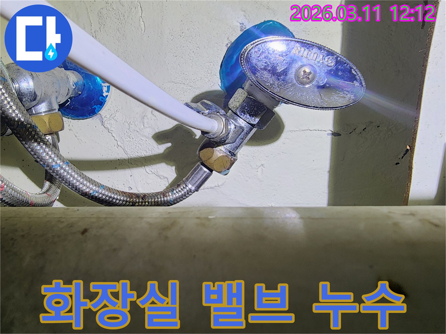 화장실-벽면에-설치된-수도-밸브와-고압호스-연결부에서-발생한-물샘-현상을-확인하는-모습입니다.