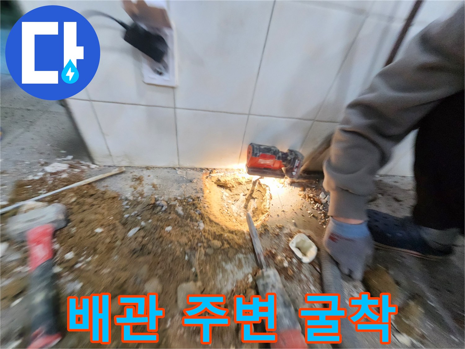 공구와 함께 노출된 배관 주변의 젖은 바닥면 상세 사진