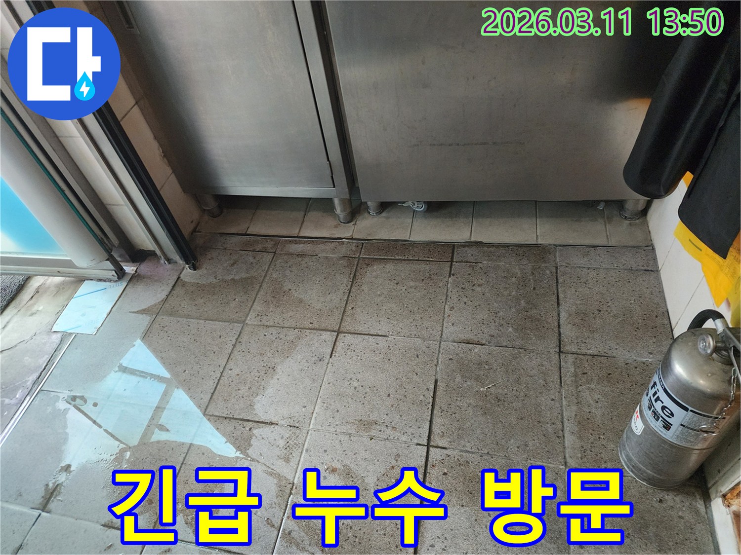 주방 바닥에 물이 고인-긴급 누수 현장에-전문가가 방문하여-상황을 진단하는 모습
