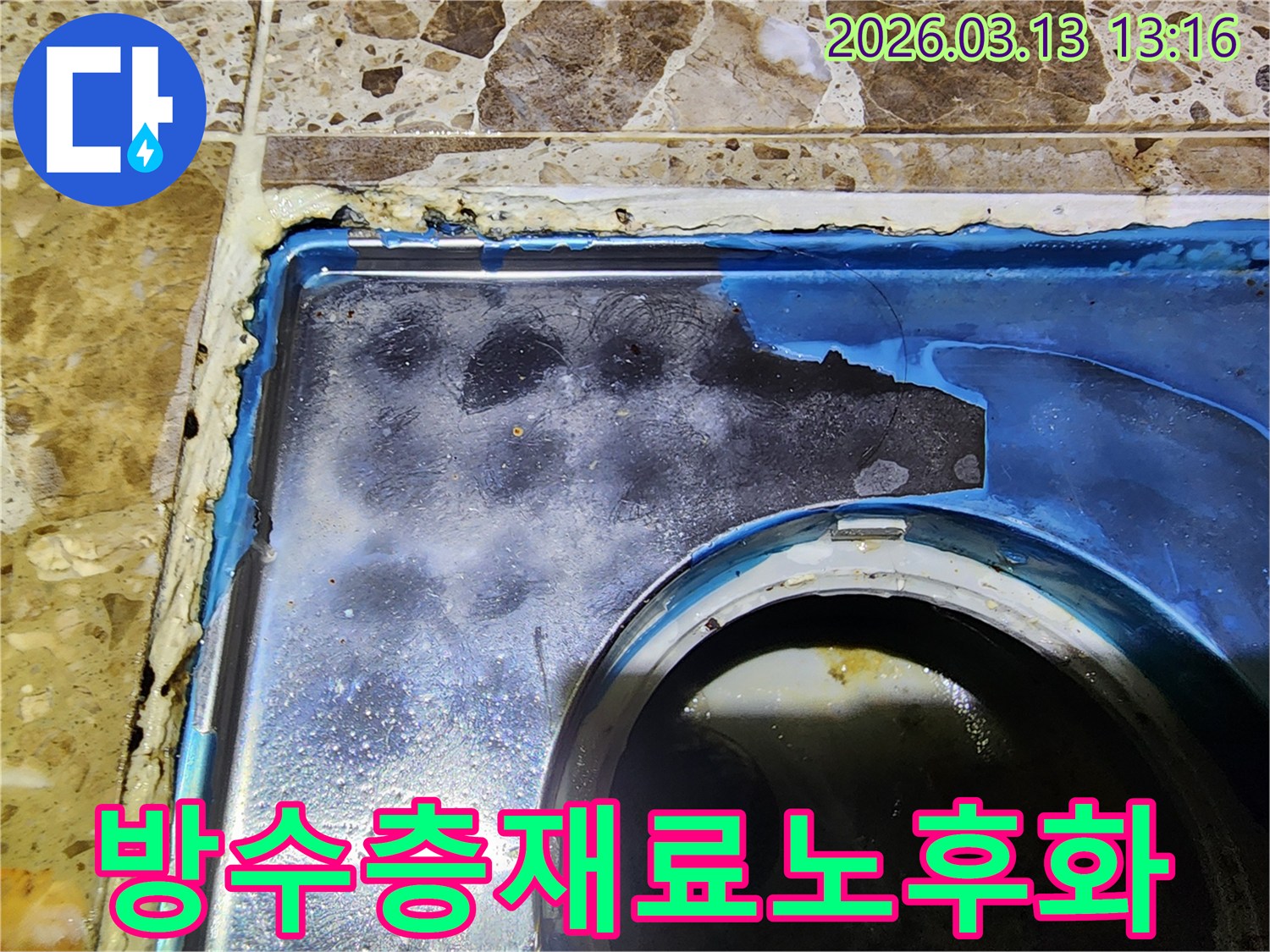 이 이미지는-빌라 화장실 바닥의-배수구 주변-오래된 방수층 재료가-노후화되어-누수가 발생한-모습을-보여줍니다