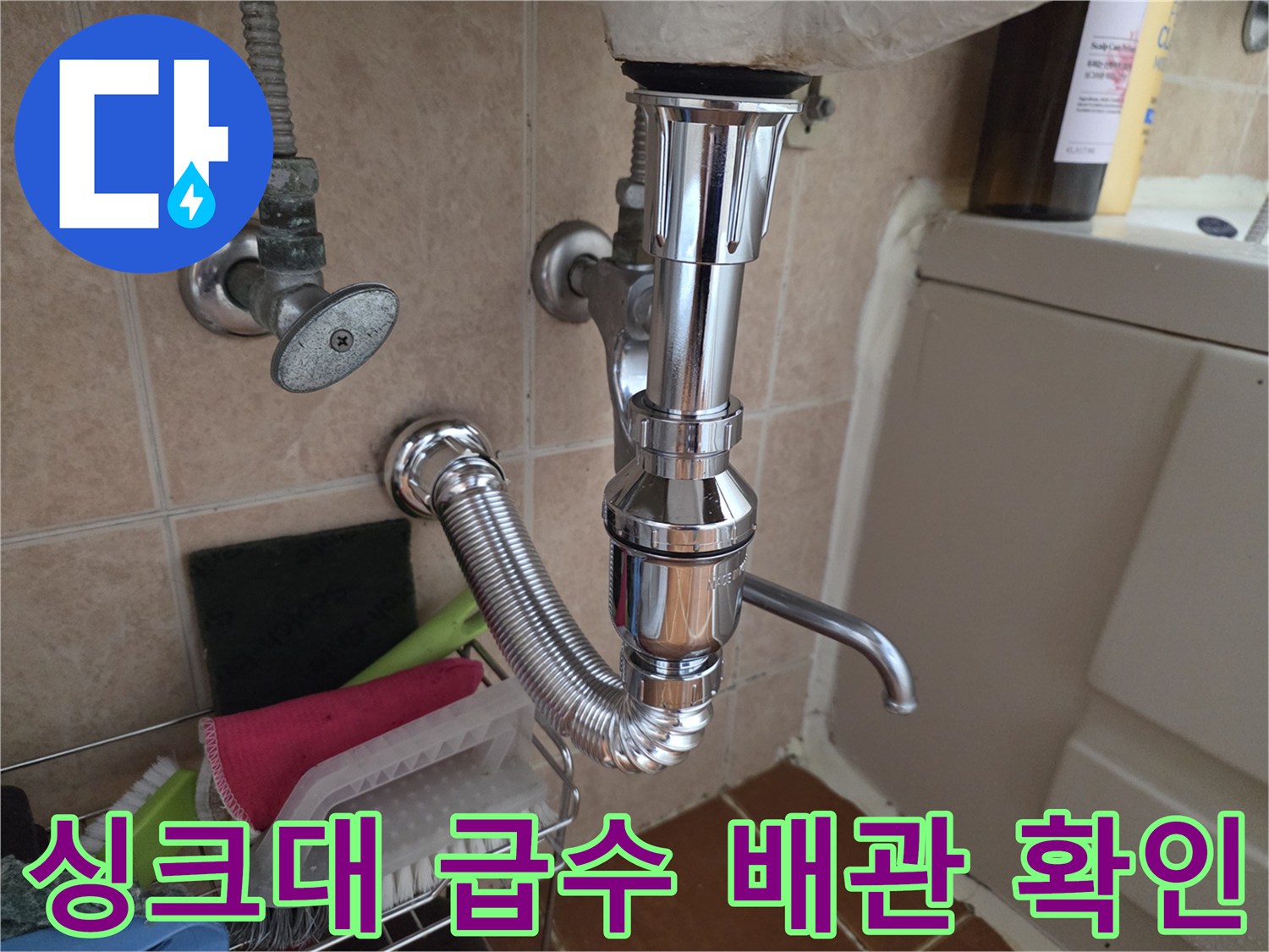 싱크대 하단에 설치된 급수 밸브와 수전 연결 호스의 모습입니다.