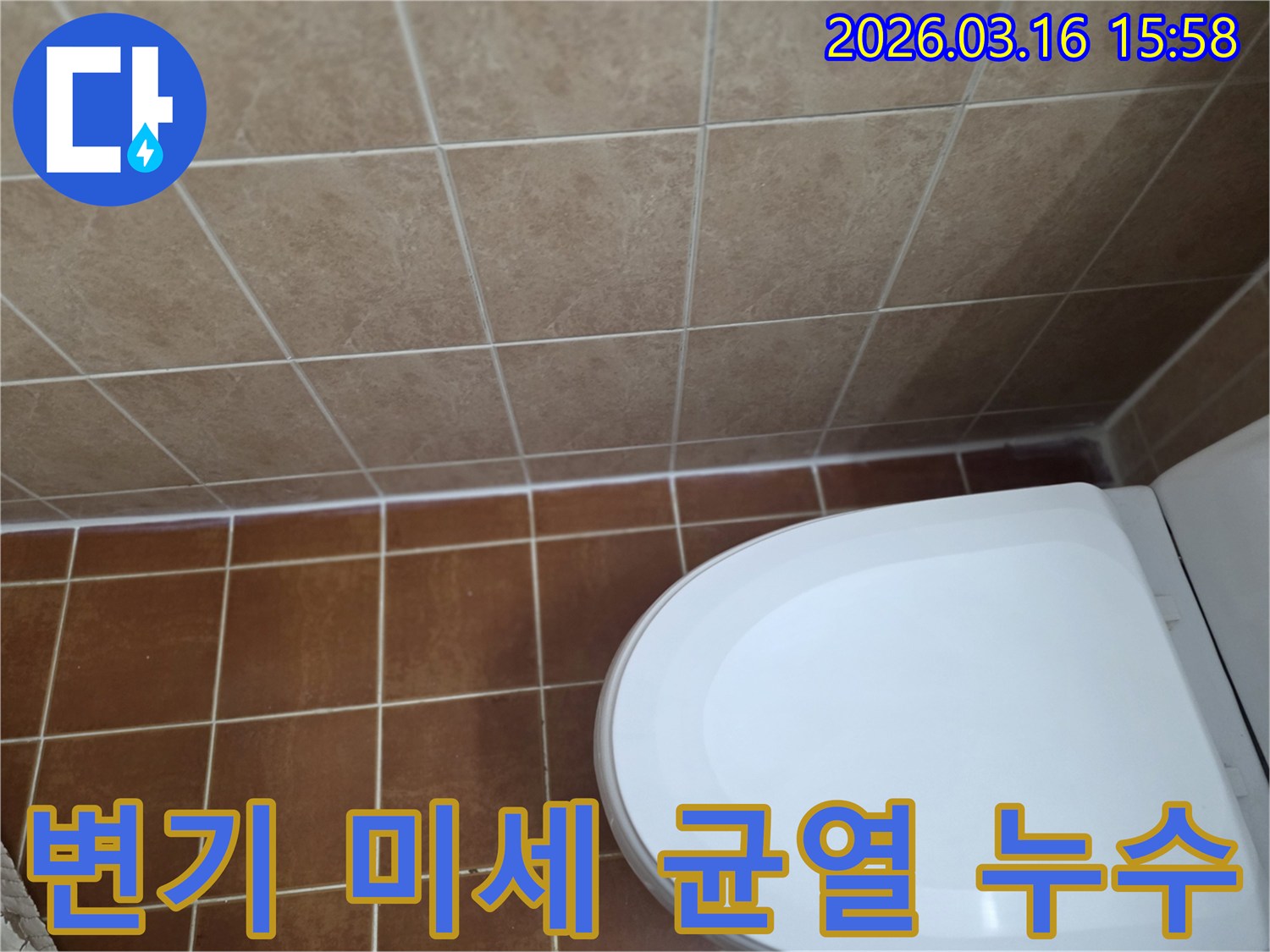갈색 타일 바닥과-벽-그리고 흰색 변기가 보이는-화장실 변기 주변 미세 균열 누수 점검 현장입니다.