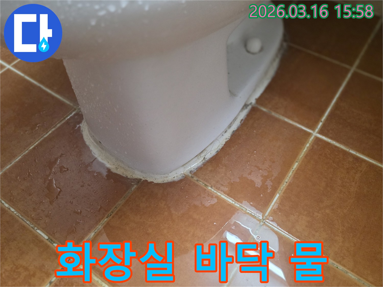 욕실 변기 아래로-물이 흘러나와-바닥 타일을 적시고 있는 모습입니다