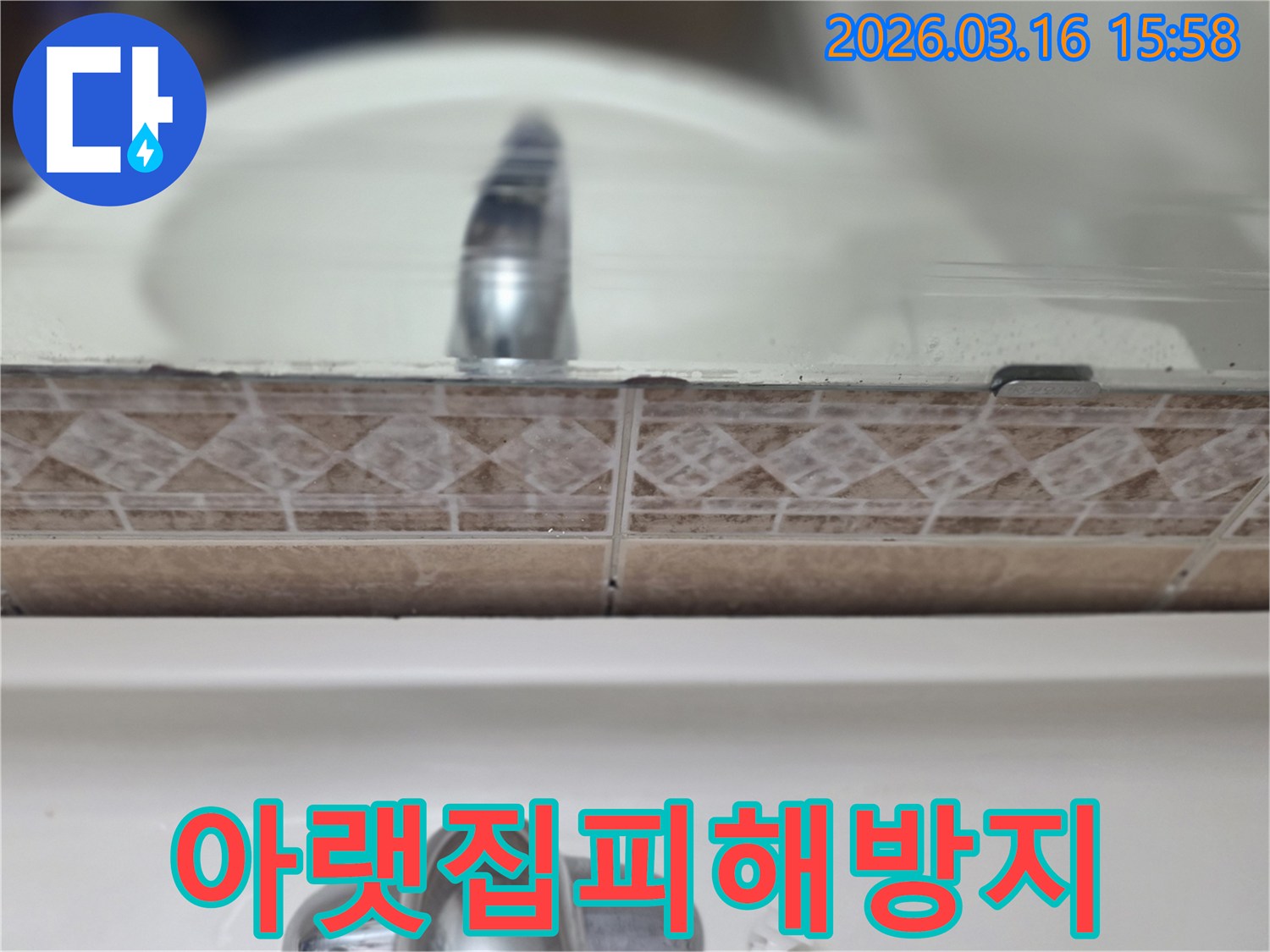 욕실-세면대-뒤-타일-틈새의-누수-흔적을-촬영하여-아랫집-누수-피해-방지를-위한-선제적-방수-공사-방안을-모색하는-사진