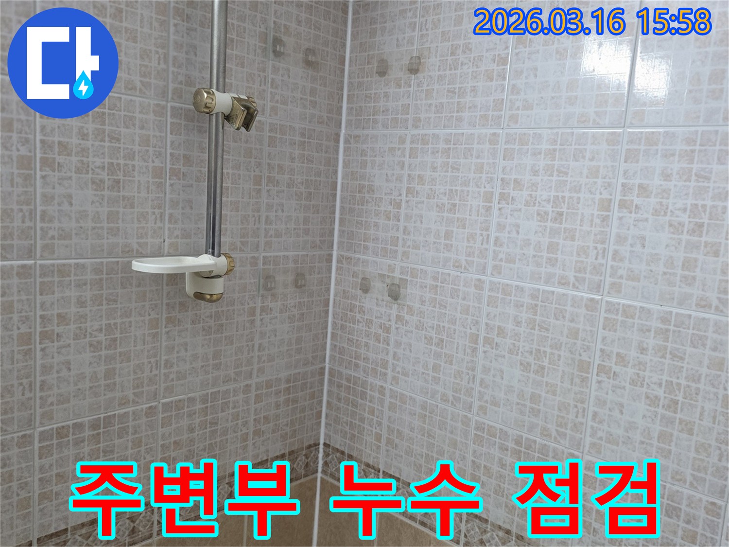 욕실 천장 타일에 물이 새어 생긴 얼룩과-주변부까지 확장하여 누수 전문가가 점검하는 모습