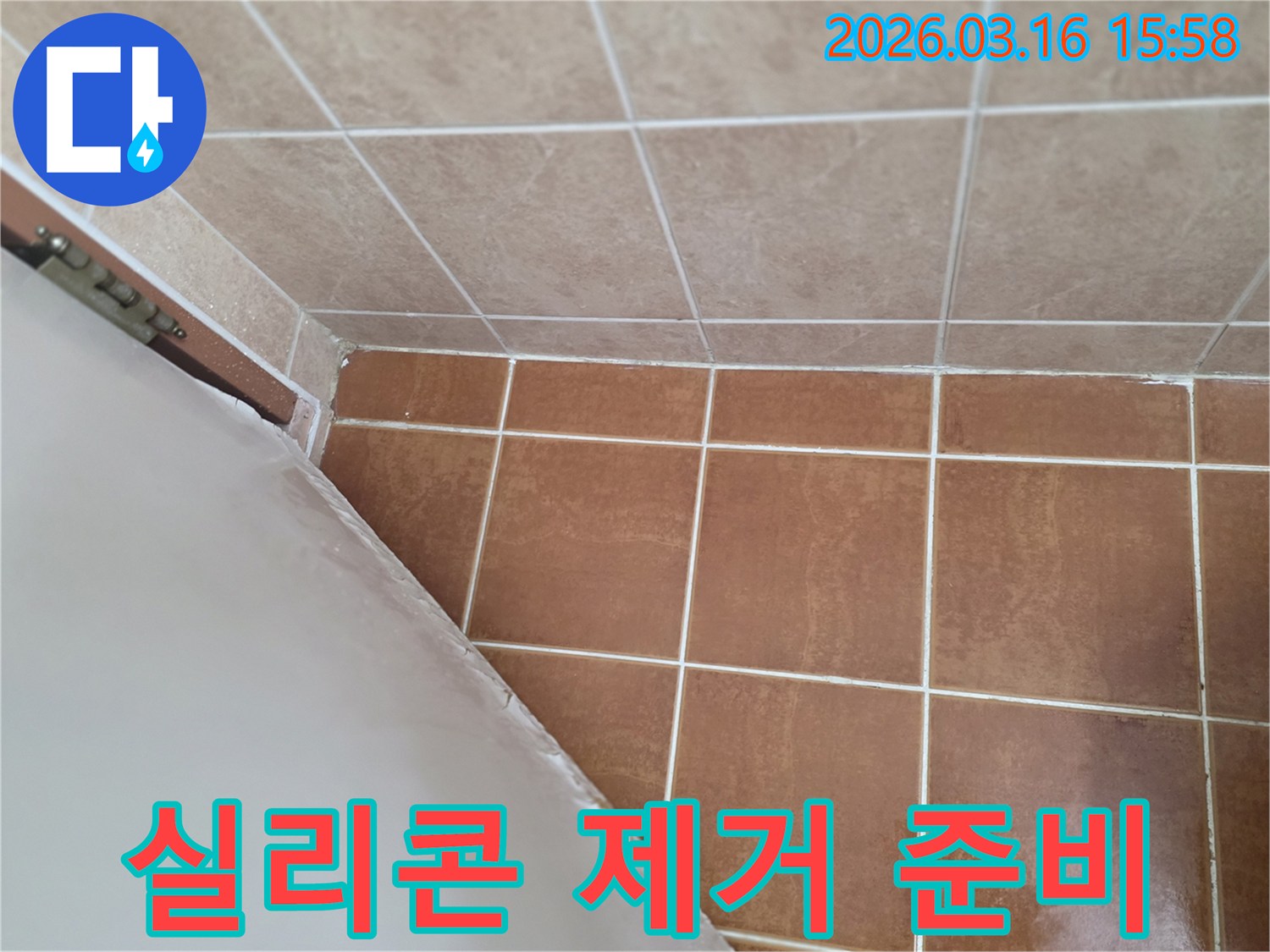 이 이미지는 욕실 코너의-오래된 실리콘을 깨끗하게 제거하여-새로운 방수 시공을 준비하는 모습을 보여줍니다.