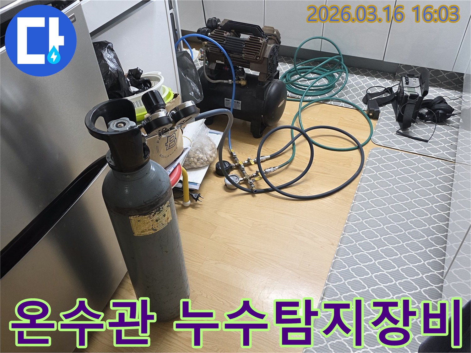 온수관 누수 지점을 정확히 찾아내기 위해-가스통과 압축기를 연결하여-정밀 탐지를 준비하는 현장입니다