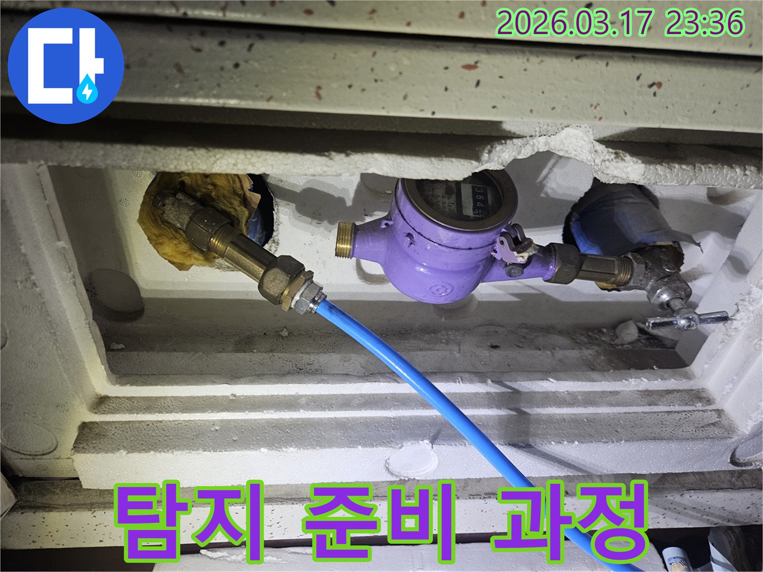 누수 공사의 첫 단계로-수도 계량기에 전문 탐지 장비를 연결하여-누수 지점을 찾아내기 위한 준비 작업을 진행하고 있습니다