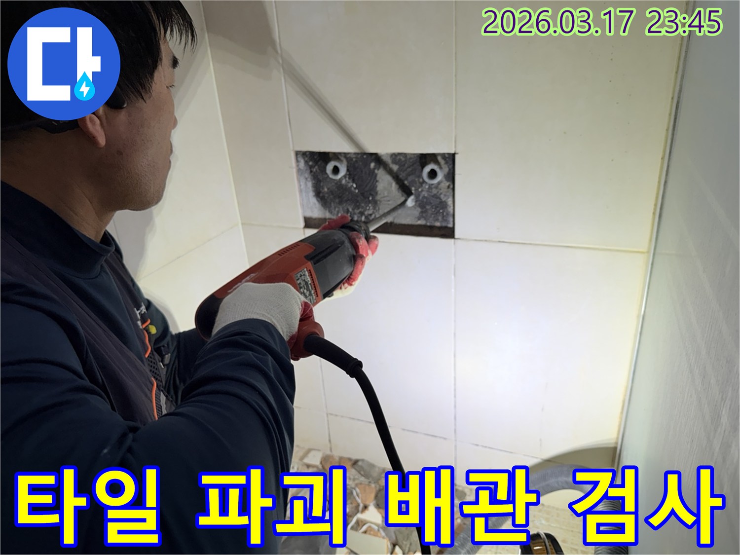 누수 전문가가 욕실 벽면 타일을 파괴하여-숨겨진 배관의 누수 지점을 정밀하게 검사하는 작업 현장입니다.