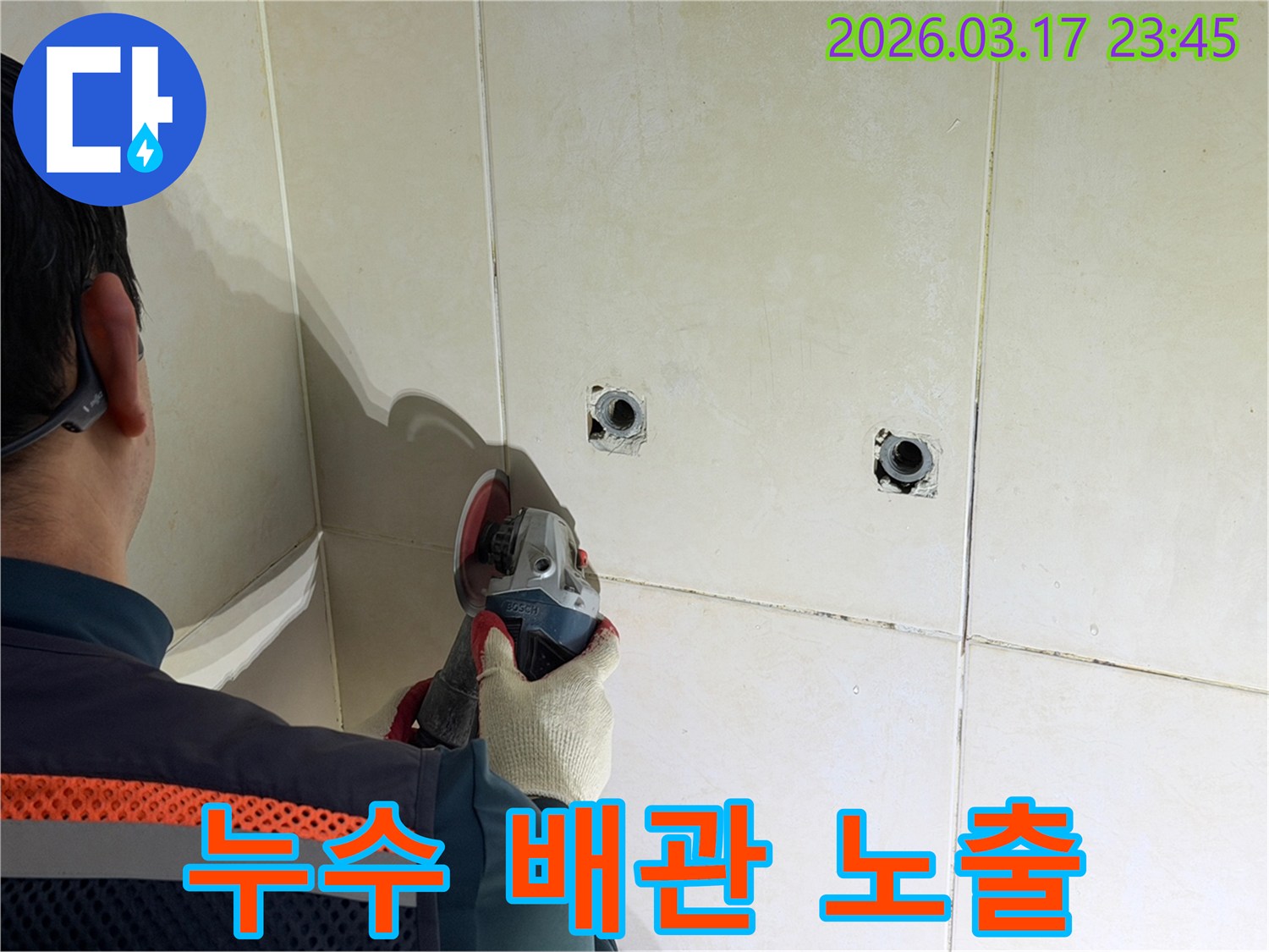 누수된 배관을-노출시키기 위해-전문가가-타일 벽면을-그라인더로-조심스럽게-커팅하고-있습니다