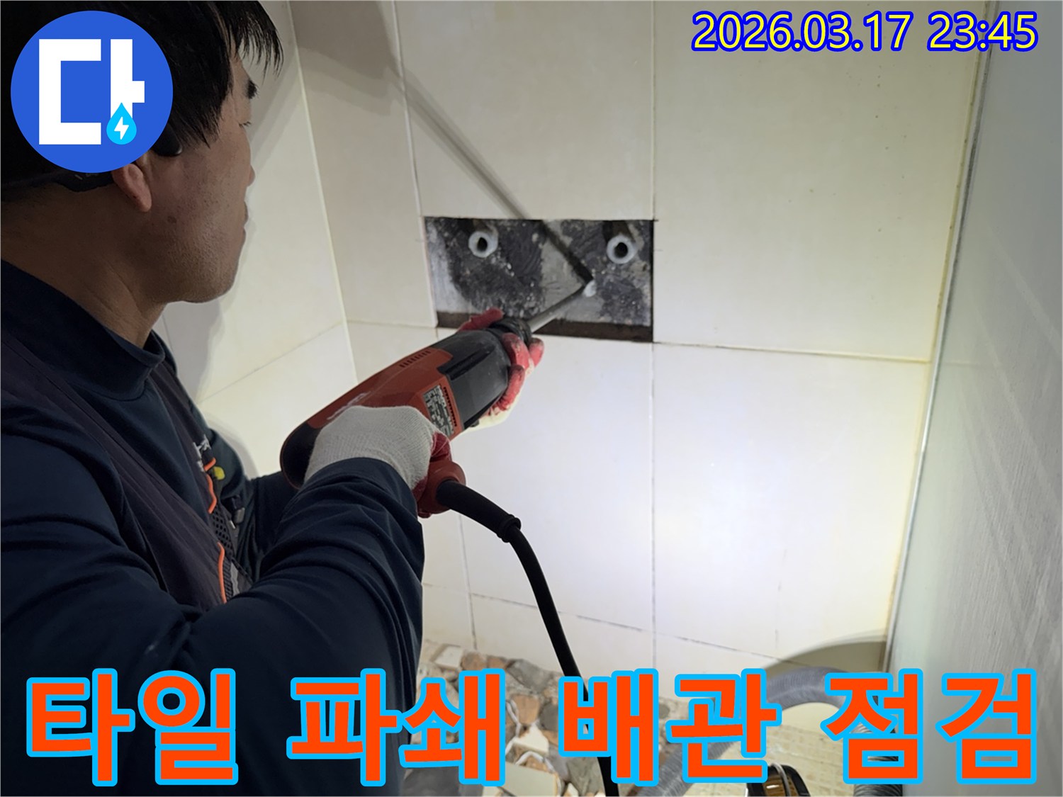 숙련된 기술자가 누수 지점을 찾아내기 위해-벽면 타일을 깨고 내부 배관을 드러내는 작업을 진행하고 있습니다.