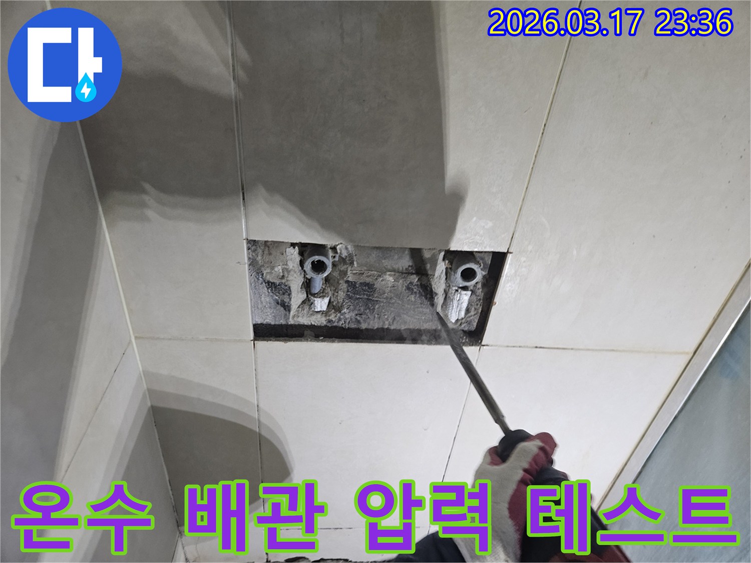 숙련된 기술자가-누수 탐지 후-타일 아래 숨은-온수 배관을-드러내고-압력 테스트를-준비하는 작업
