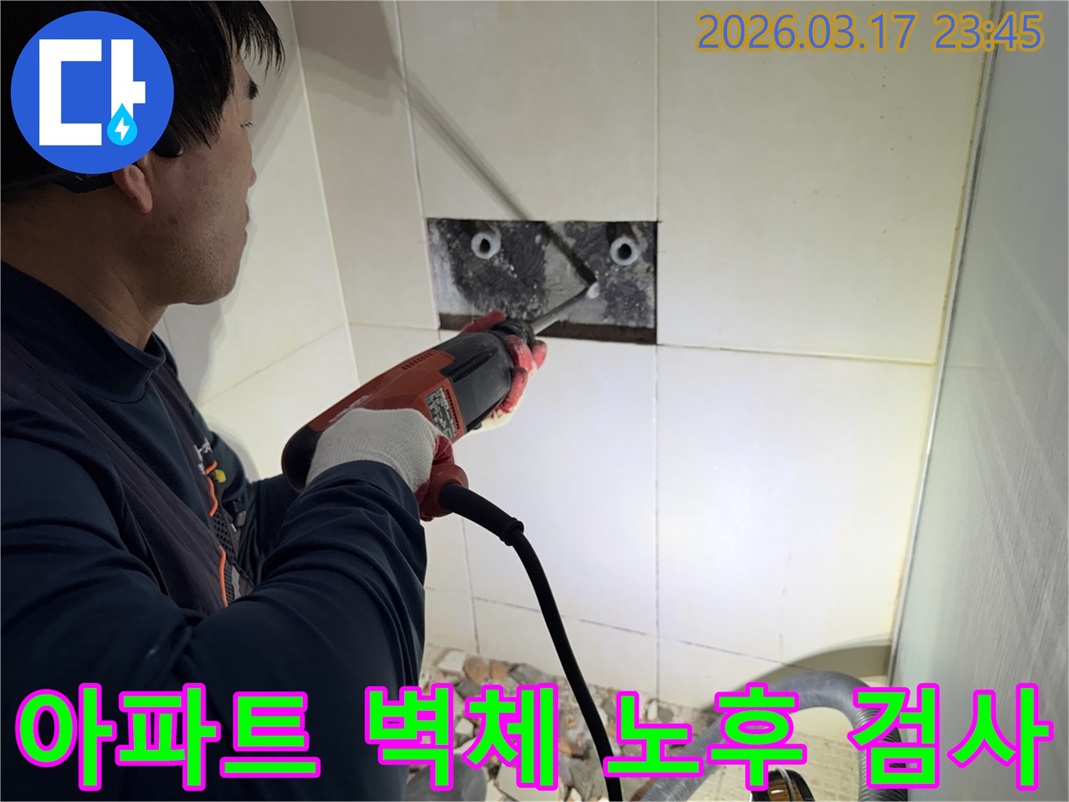 숙련된 기술자가 아파트 욕실 벽체를 해체하여-내부 배관의 노후화 여부를 육안으로 검사하는 작업 현장입니다.