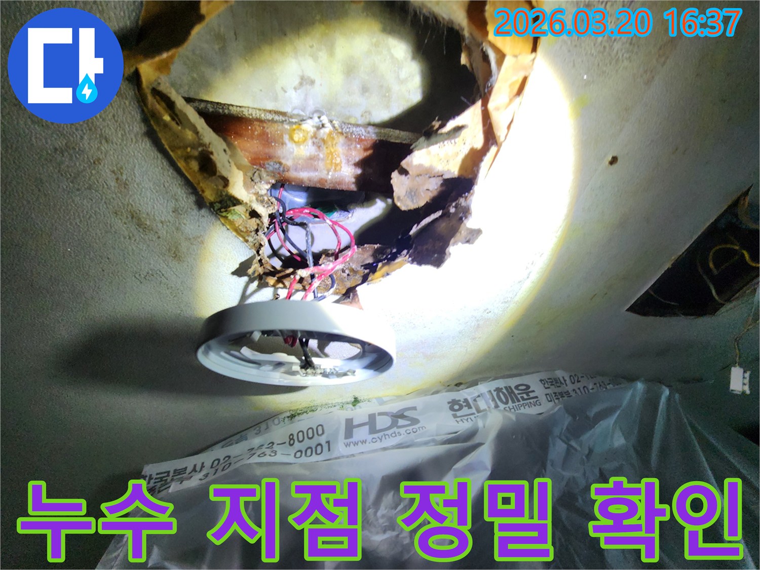천장 누수-현장에서-부식된-천장 마감재와-노출된-배관을-조명으로-확대하여-점검하는-모습입니다