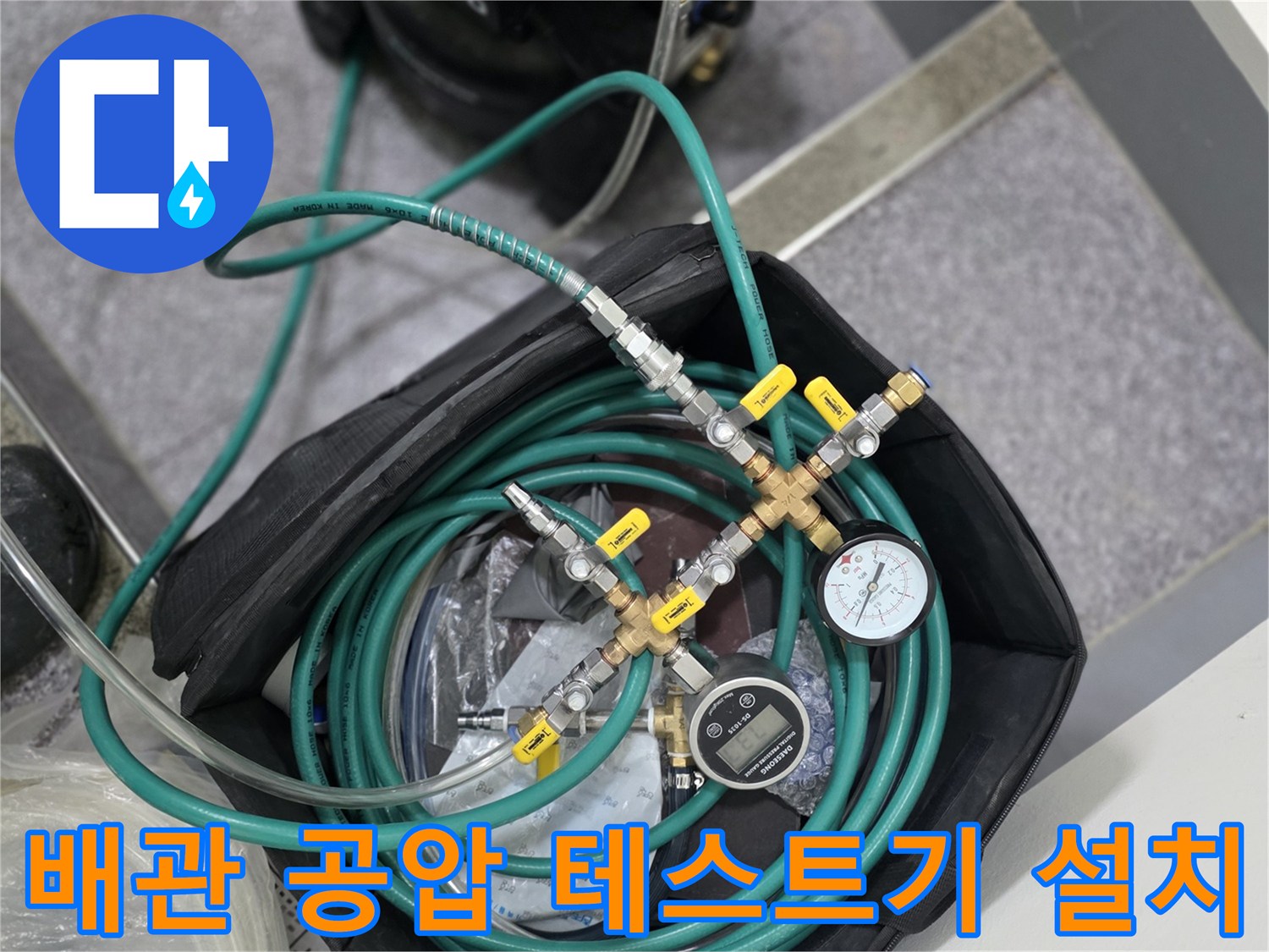 싱크대 하부 배관 점검을 위해 준비된 컴프레셔와 압력 측정 장치