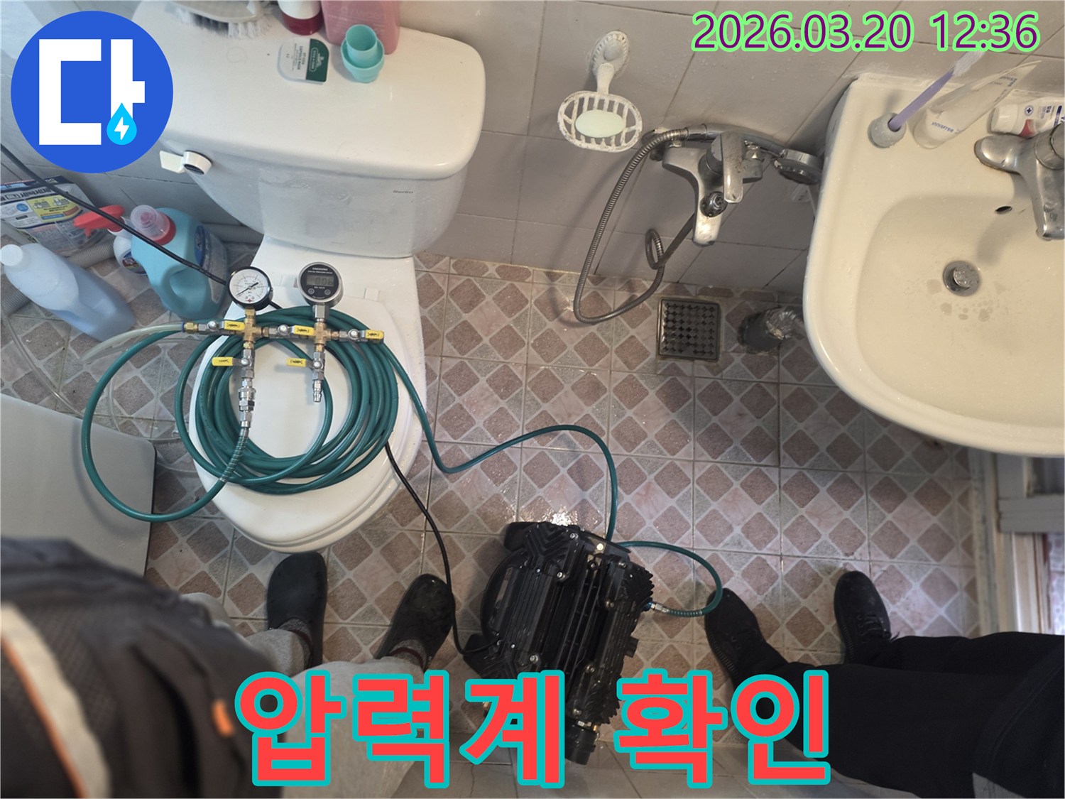엔지니어가-욕실 바닥 누수 원인을 찾기 위해-전문 장비를 연결하고-압력 검사를 시작하는 장면입니다.
