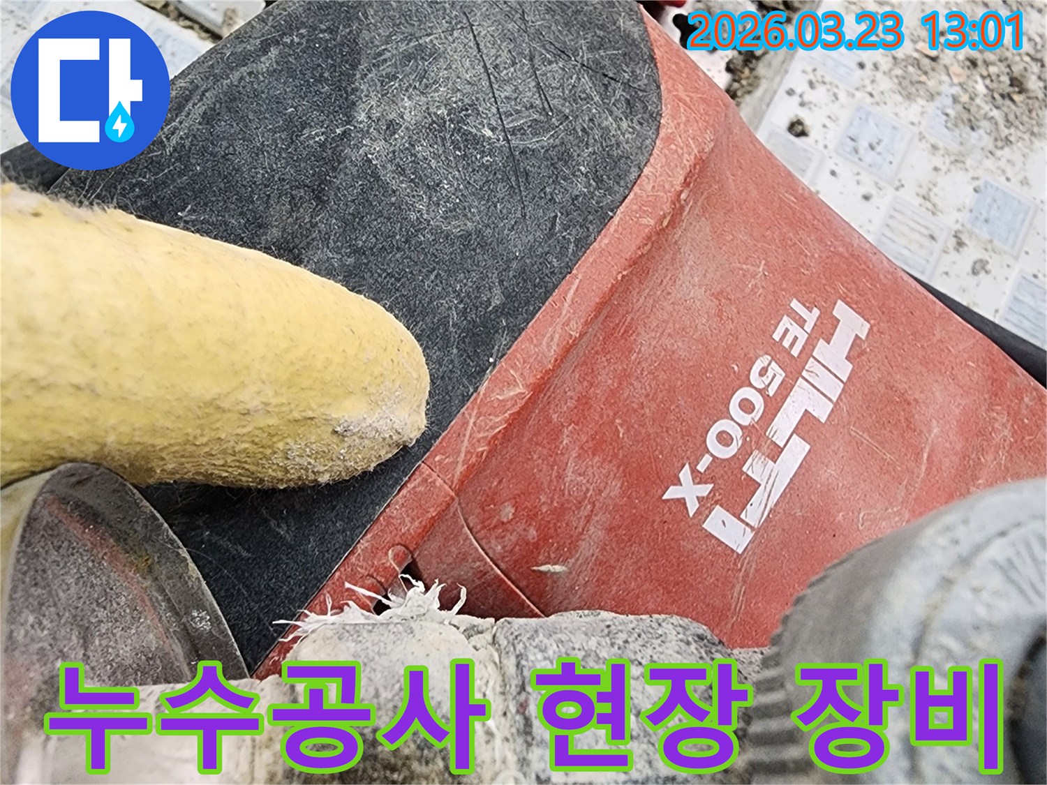 누수 공사 현장에서-전문 해머 드릴과-배관 연결부의-작업 모습입니다.