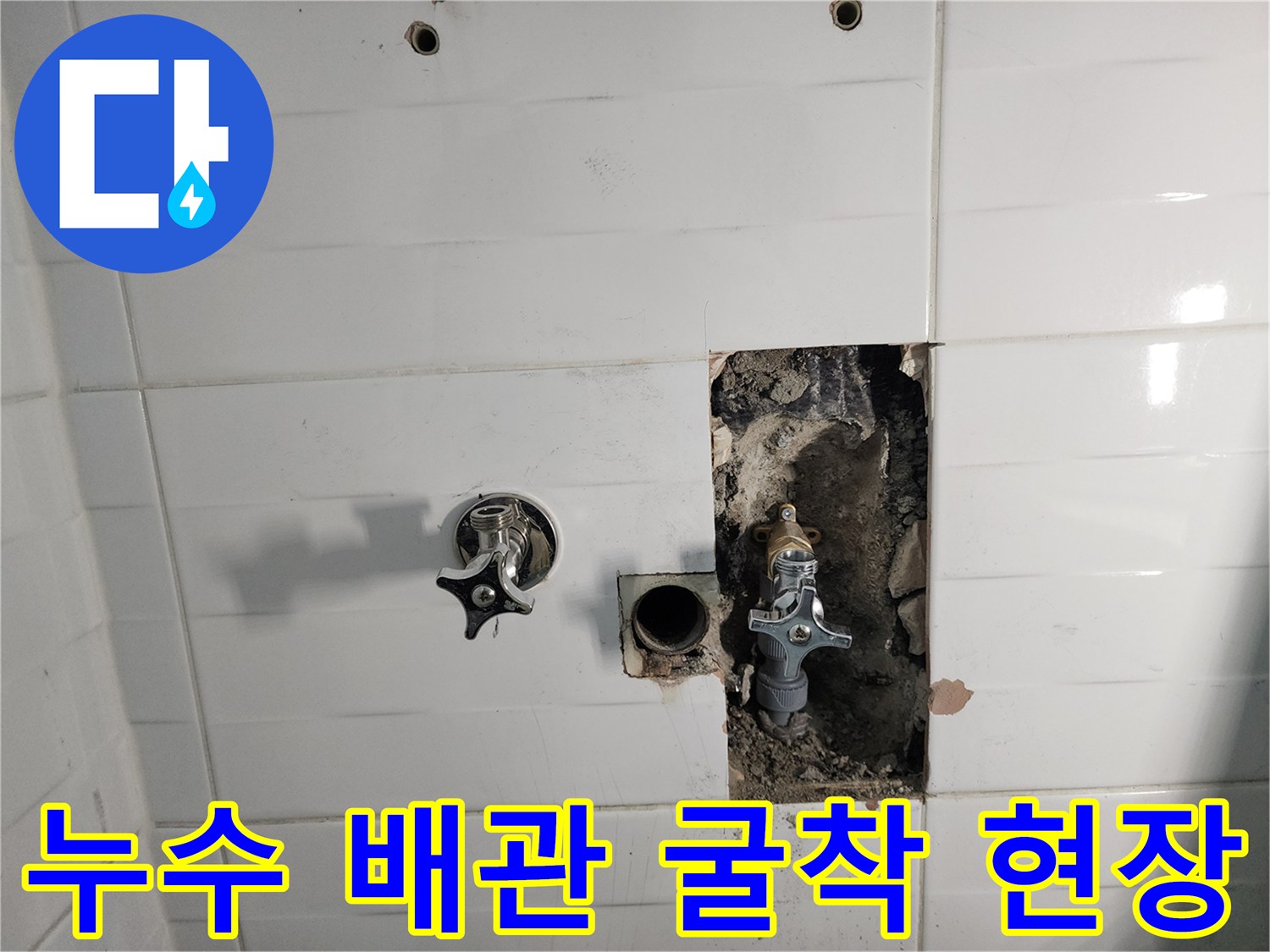 타일이 제거된 화장실 벽면 내 노출된 수도 부속품