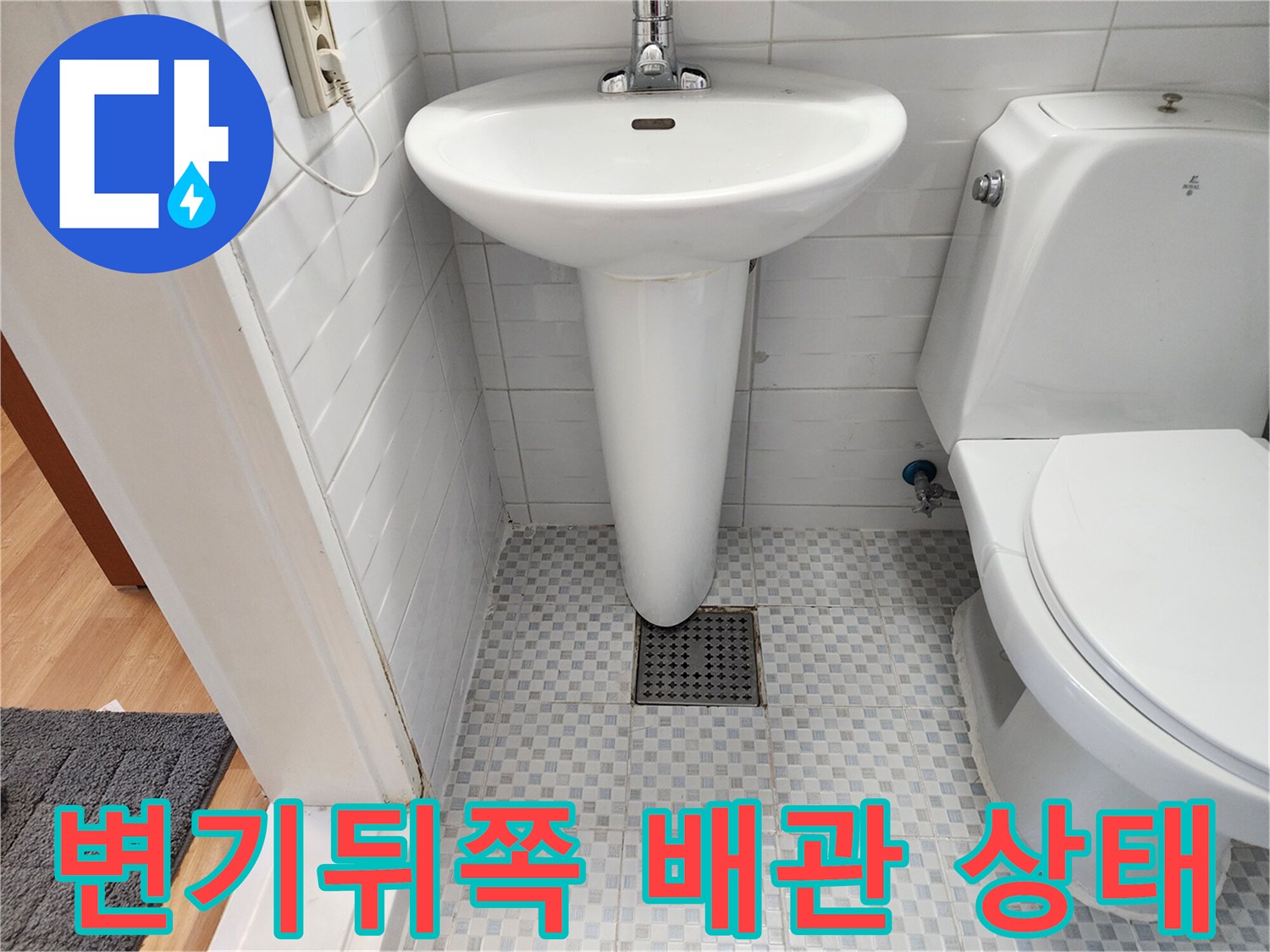 화장실 변기 뒤쪽 벽면 타일과 배관 주변 모습입니다.