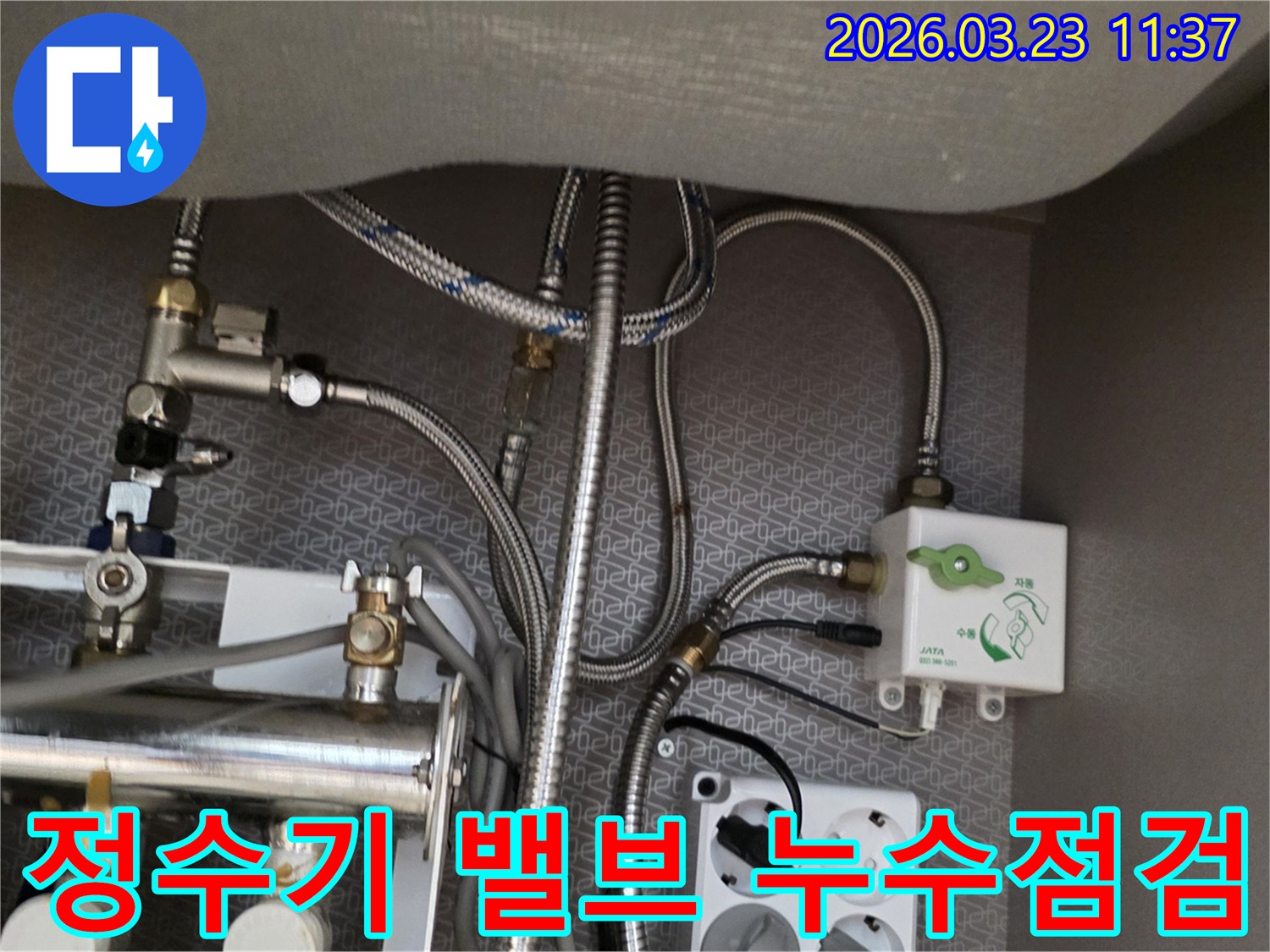 싱크대 하부장 내부의 복잡한 수도-배관과 정수기 연결-밸브-전기 콘센트가 보이는 이미지입니다.