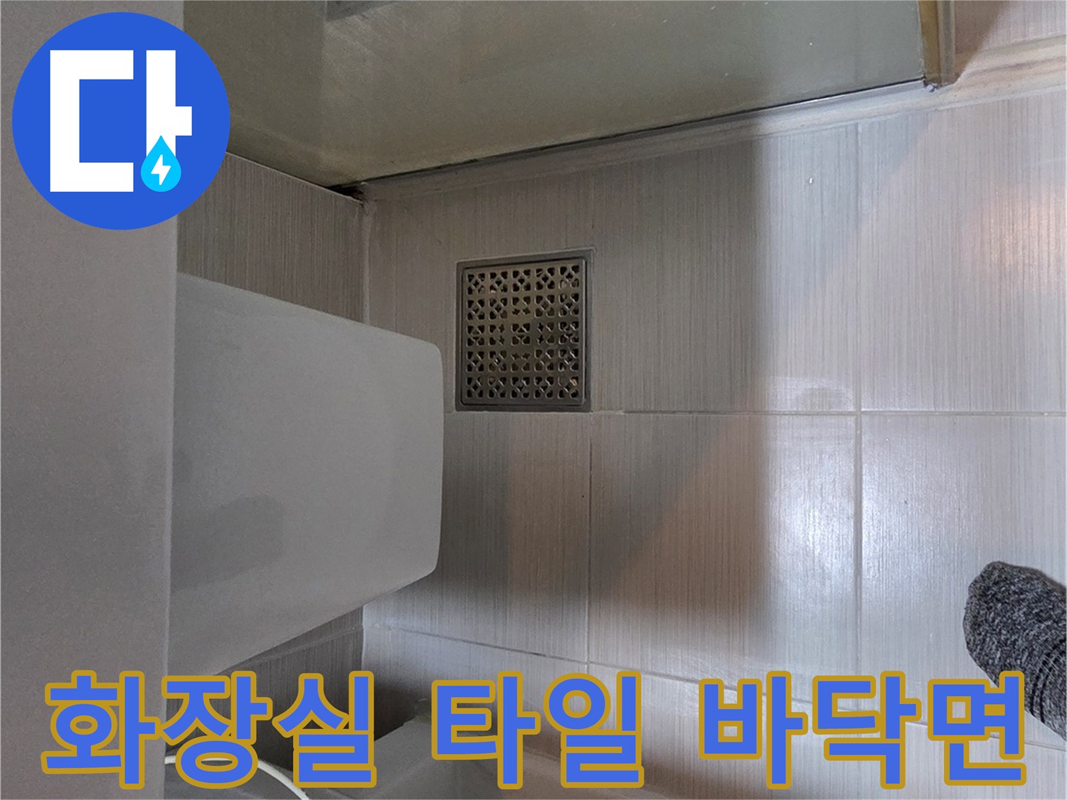 변기 옆 유가와 화장실 바닥 타일이 보이는 사진