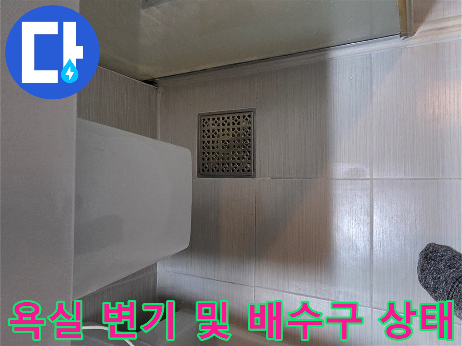 변기 하단과 바닥 배수구가 인접한 욕실 내부 모습