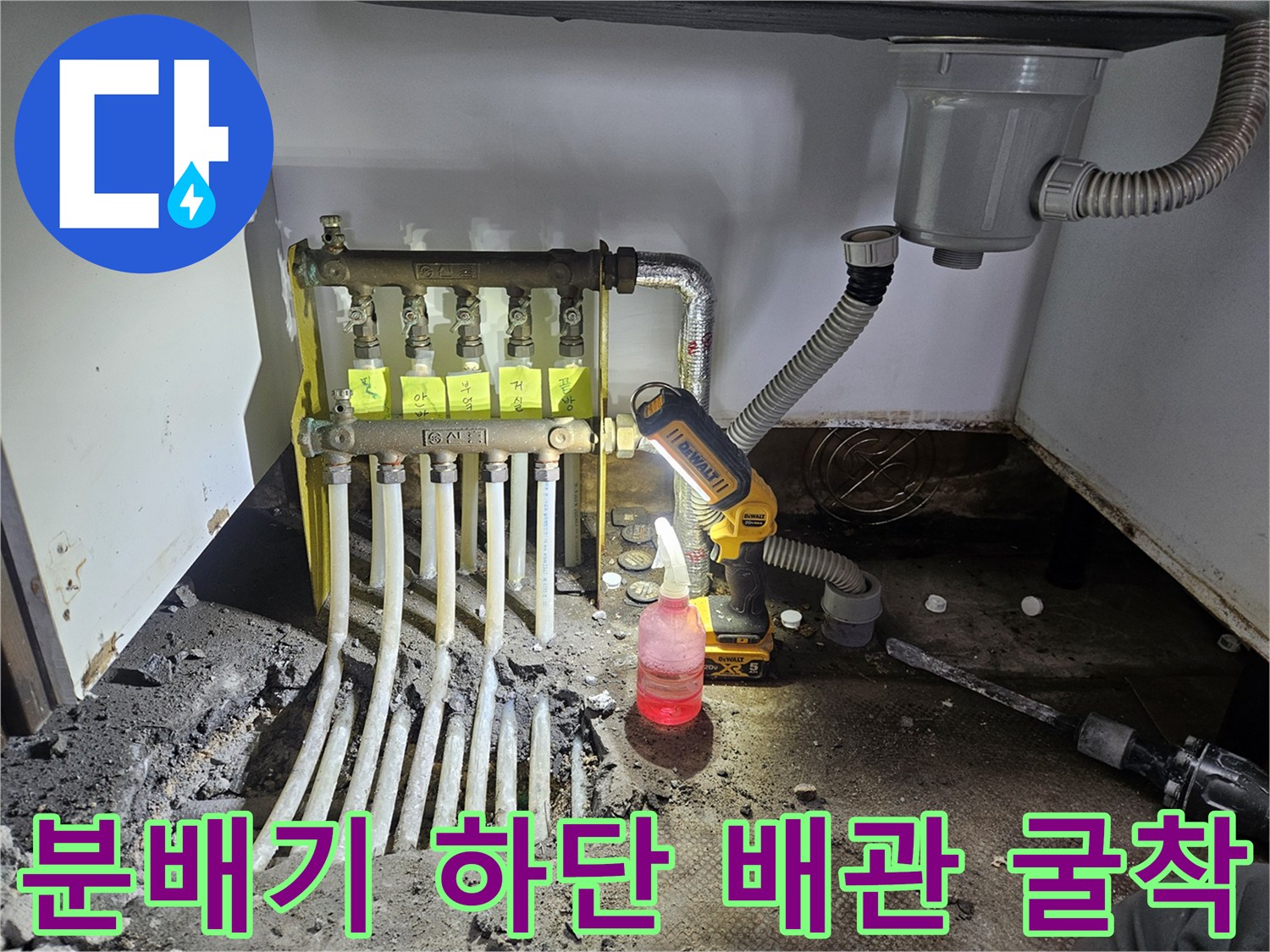 난방 분배기와 연결된 다수의 배관이 노출된 싱크대 하단 누수 현장