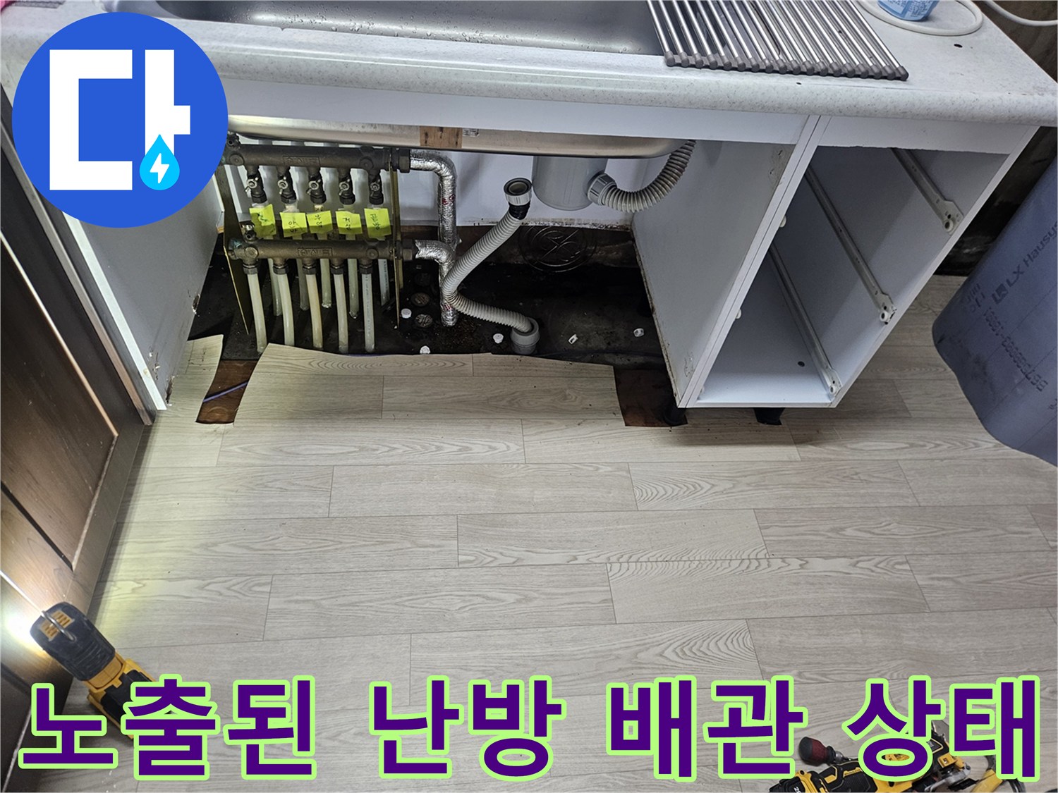 싱크대 하부 가구 뒤편에 드러난 노후된 난방 분배기와 배관 연결 부위