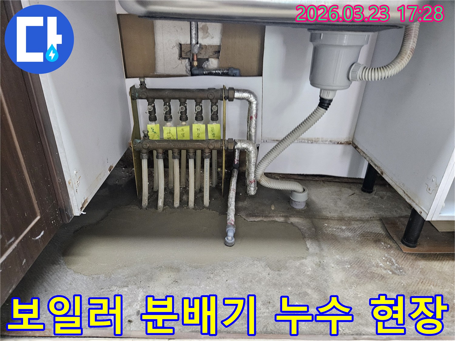 싱크대 하부-보일러 분배기에서-발생한 누수를-전문가가-진단하고-수리하는 모습입니다