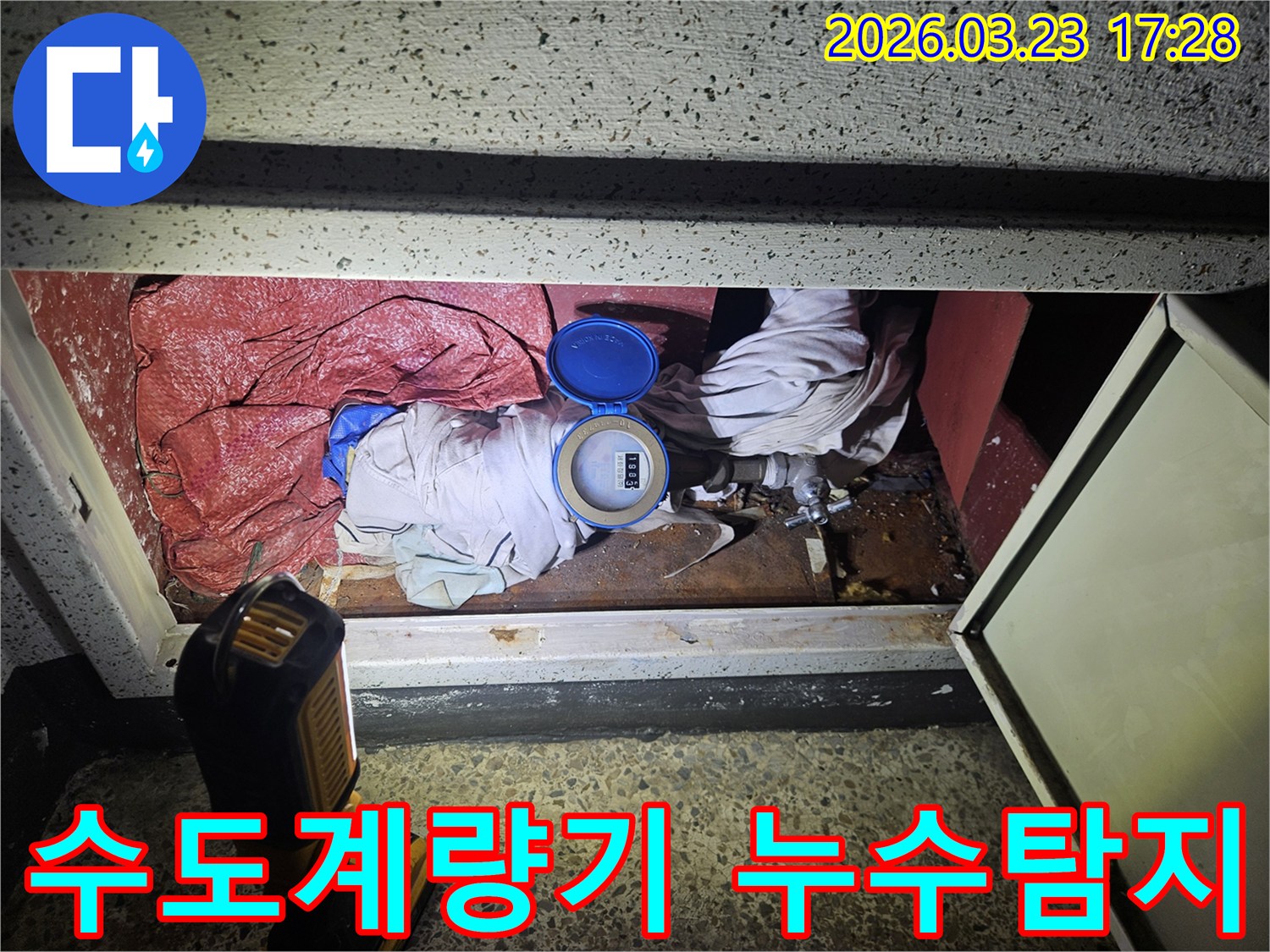 어두운 공간에서 물 계량기 주변을 정밀하게 확인하는 누수 탐지 현장