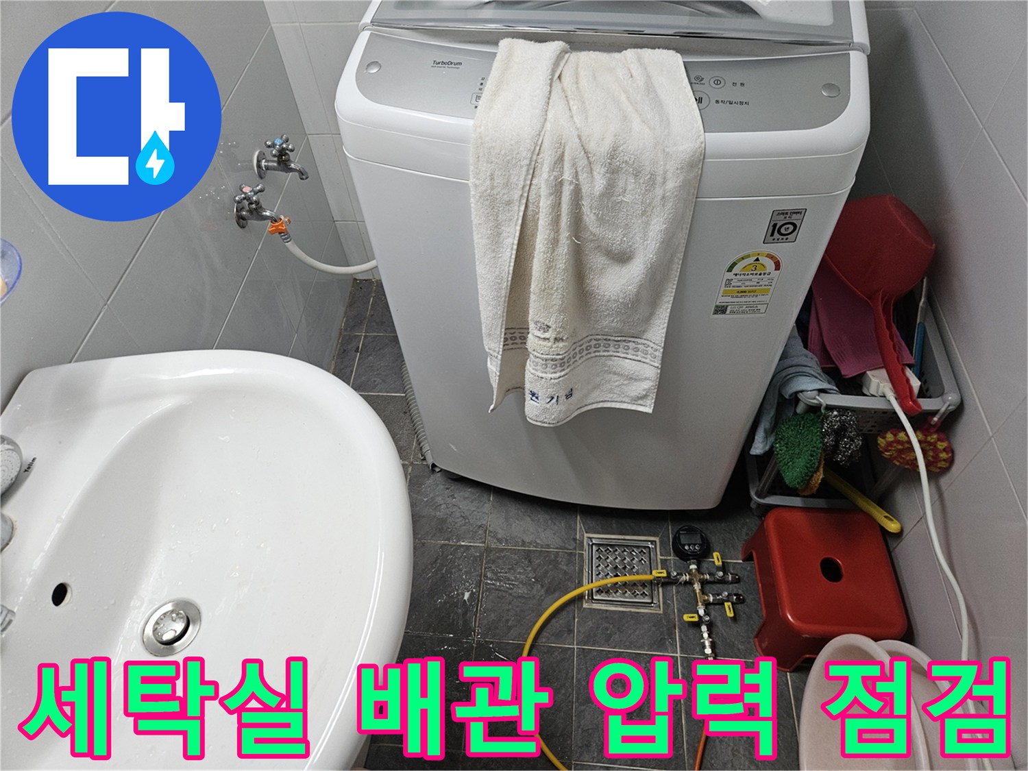 세탁기 아래쪽 수도 배관에 디지털 압력계를 연결하여 공압 테스트를 진행하는 모습입니다.