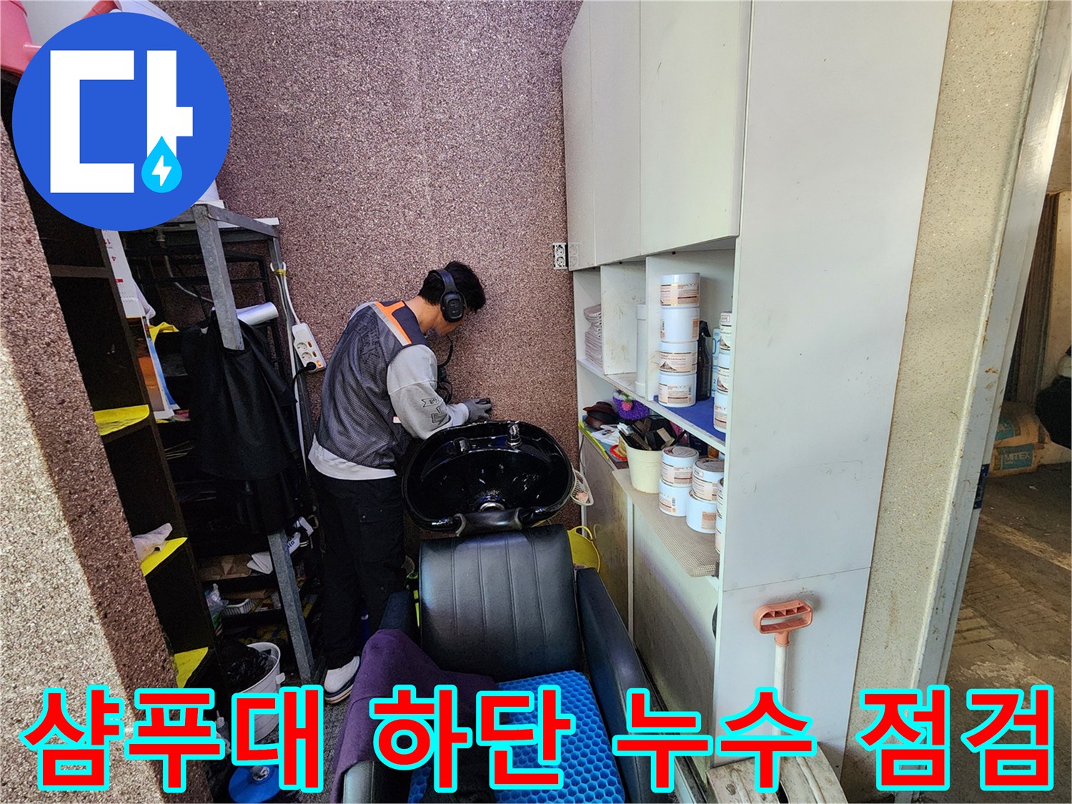 샴푸대 아래쪽 배관 연결 부위를 세밀하게 살피는 모습