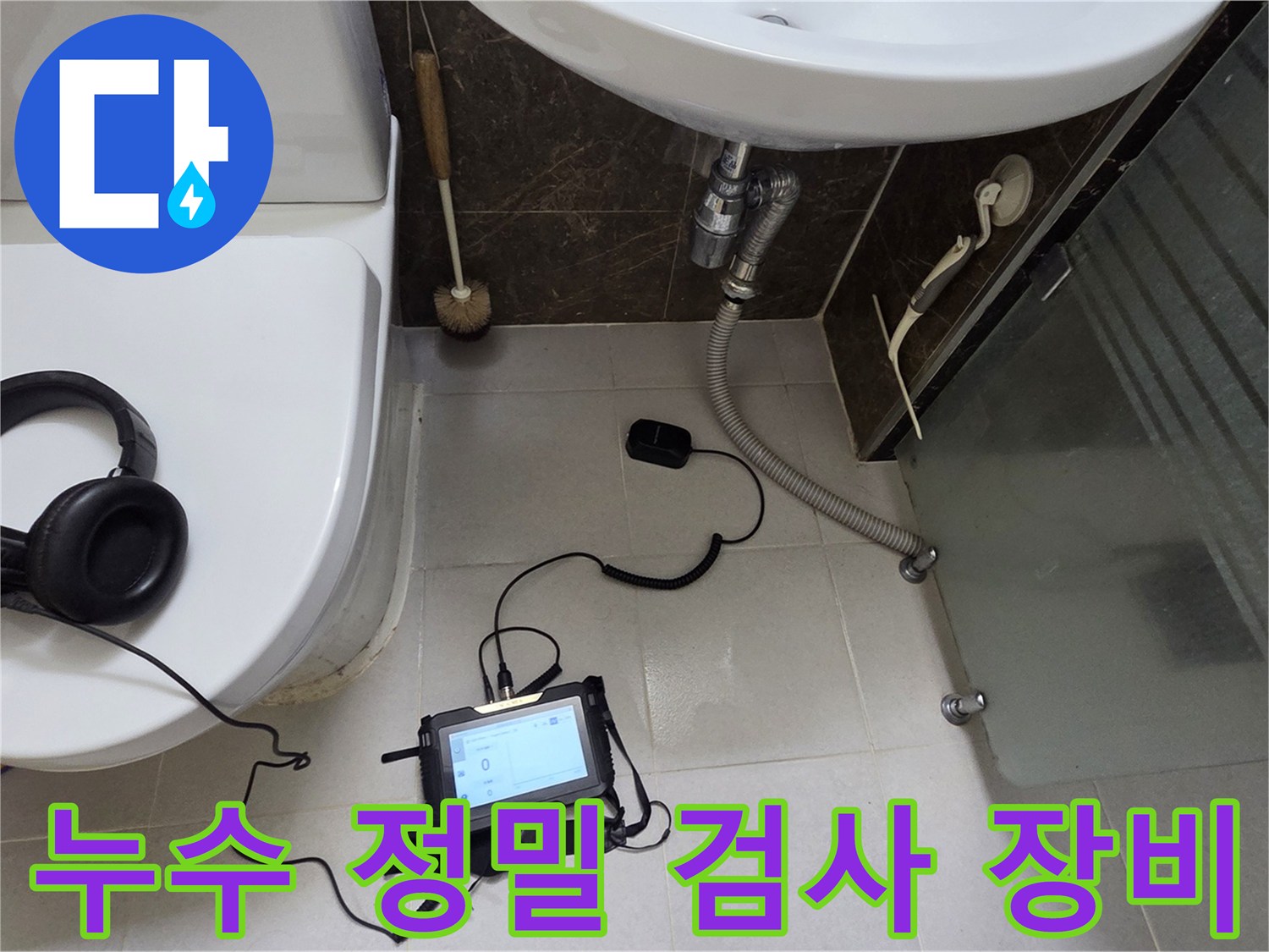 변기 옆 바닥에 설치된 배관 압력 측정 장치와 청음 헤드폰