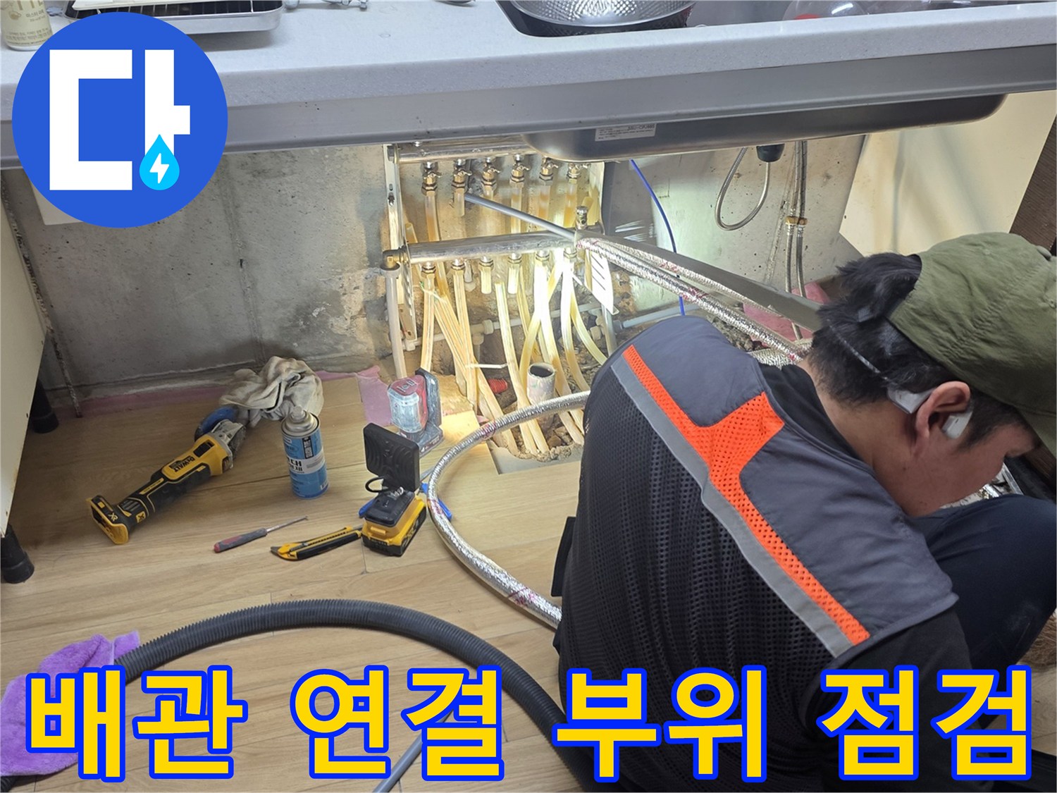 싱크대 하부장 배관 주변을 정밀하게 살펴보는 작업자