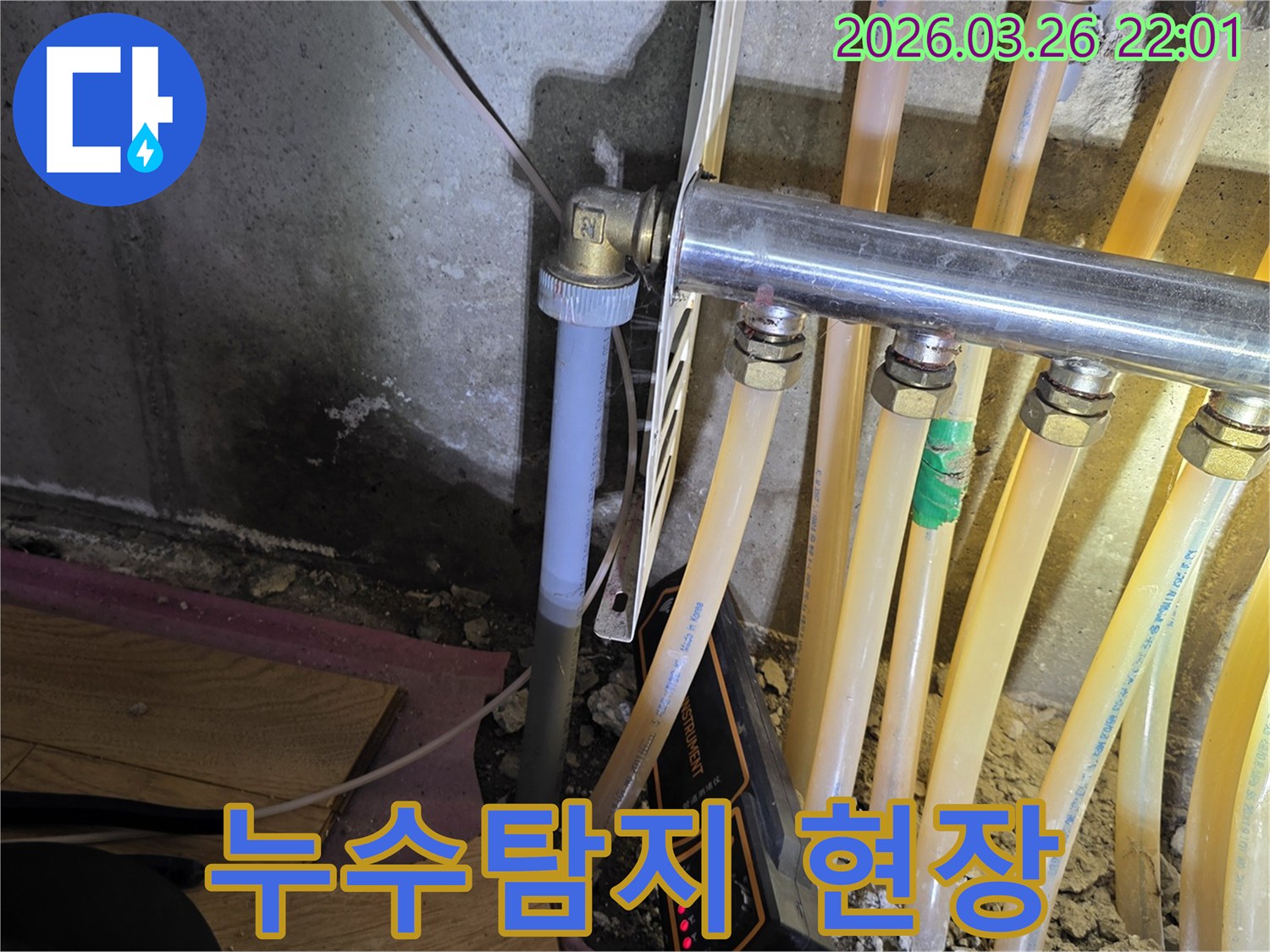 이 사진은-누수 탐지 전문가가-배관 누수 원인을-찾기 위해-정밀 장비를-활용하는-모습을-보여줍니다.
