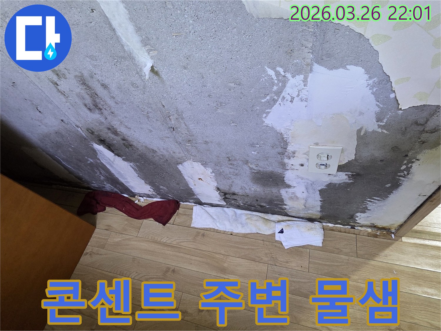 전기-콘센트-주변으로-물기가-스며들어-벽지가-손상되고-얼룩진-콘크리트-벽면-아래-수건이-놓인-위험한-누수-현장