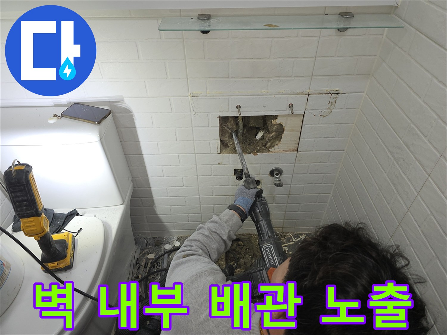 콘크리트 벽면을 뚫어 매립된 배관의 위치를 드러내는 굴착 작업 모습입니다.