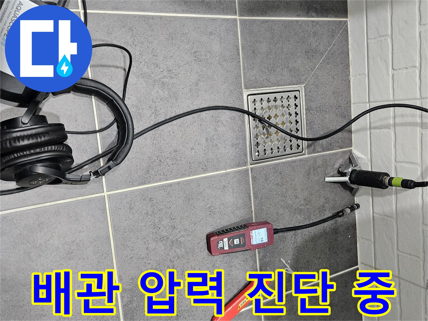 타일 바닥 위 디지털 게이지와 가스 탐지 장비의 모습