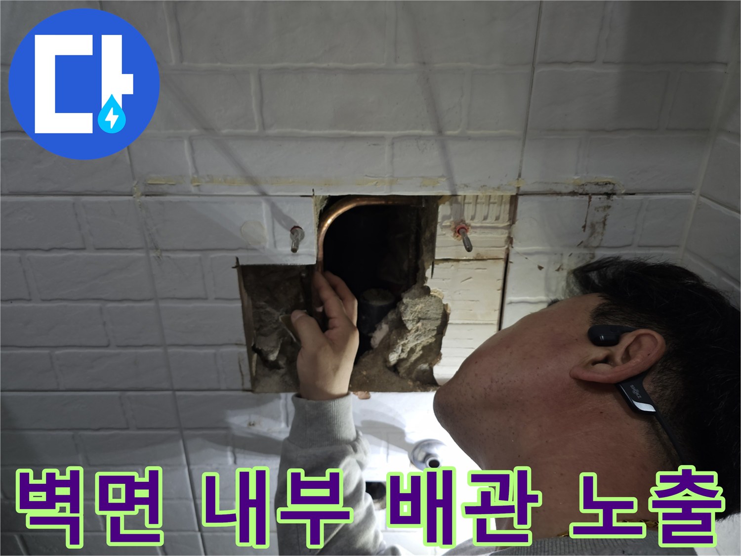 타일을 제거하고 벽체 안쪽의 구리 배관을 점검하는 공사 현장
