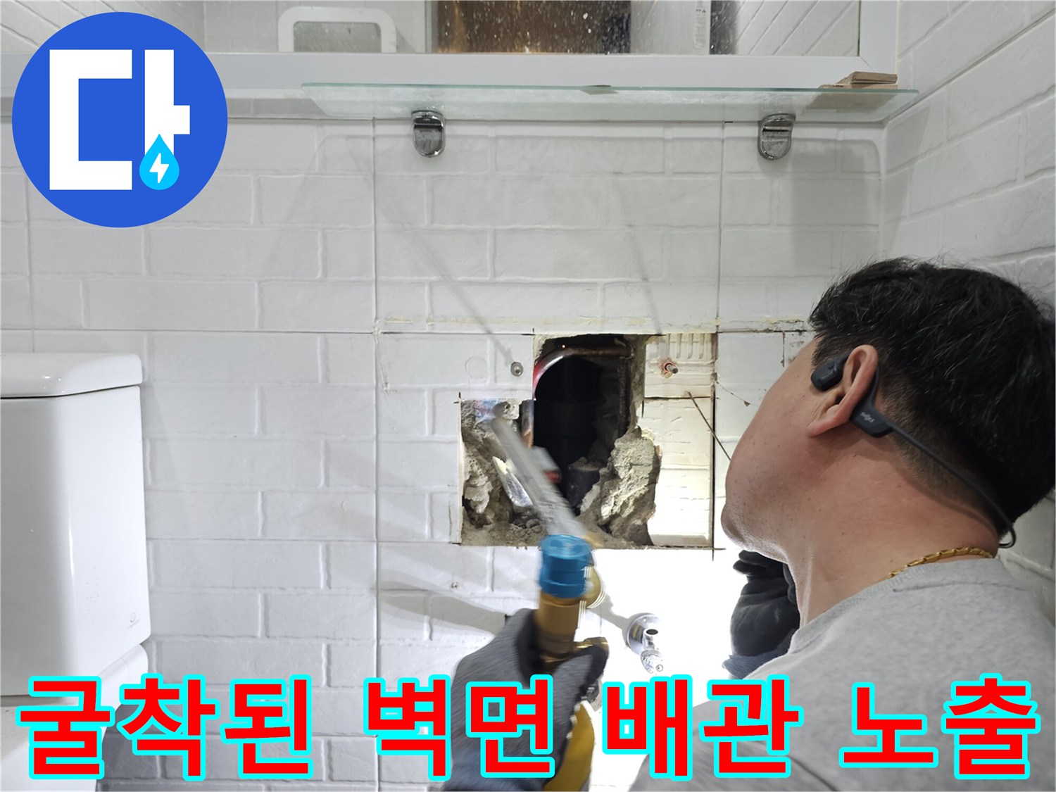 화장실 벽 내부-노출된 배관과 굴착된 콘크리트 부위