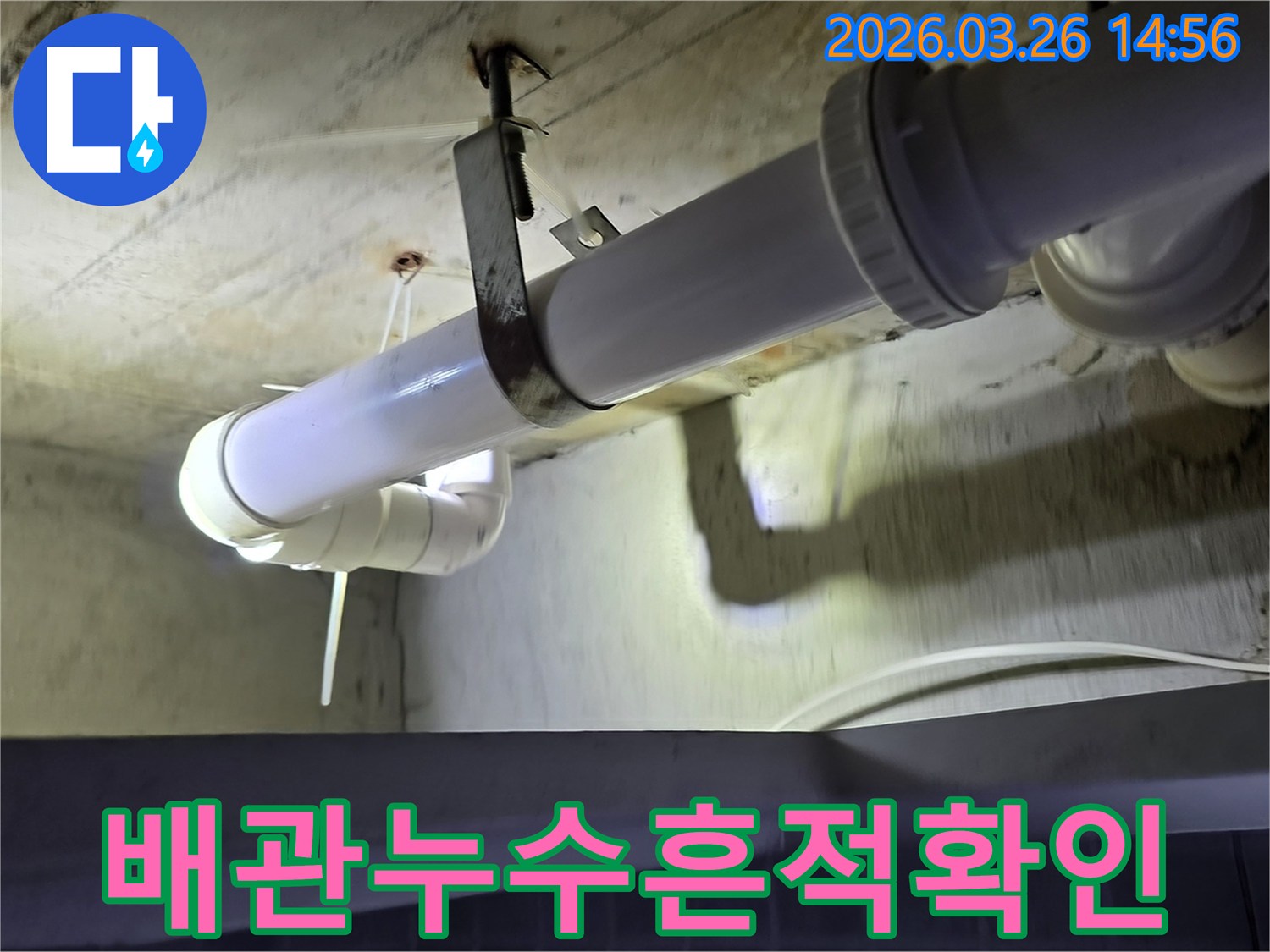 어두운 천장 아래-배관에서 발생한-누수를-조명으로 비춰-정밀하게 검사하는-장면입니다