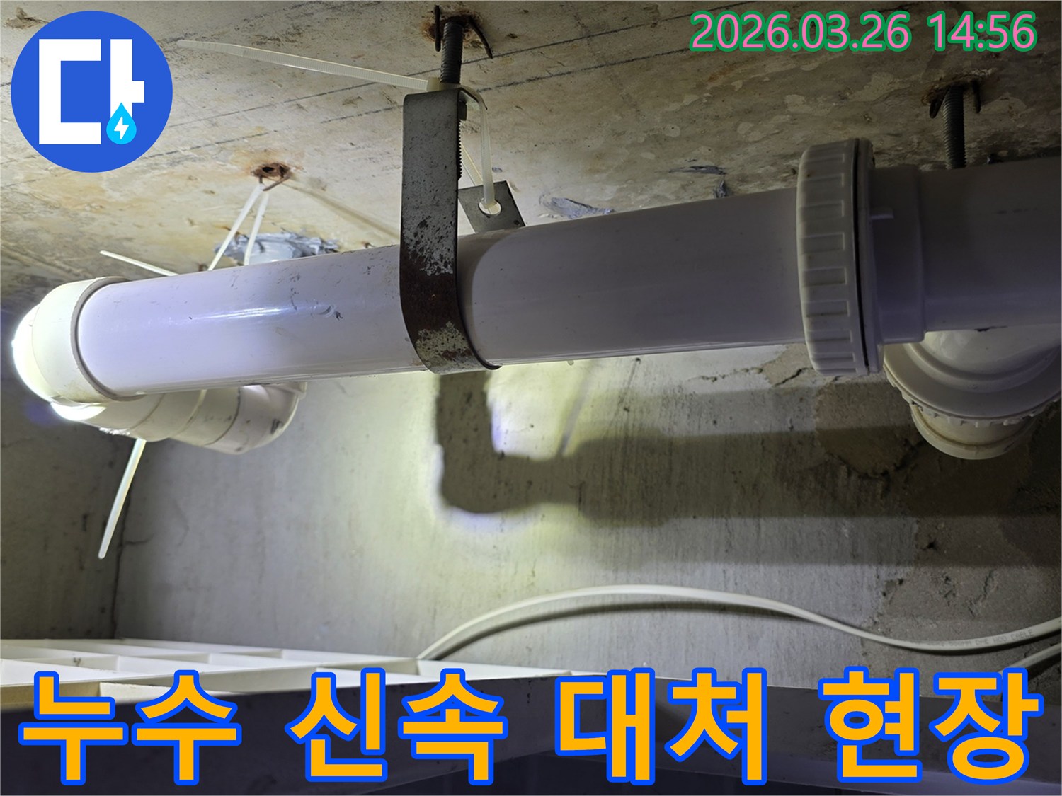 콘크리트 천장 아래에 설치된-하얀색 배관과-그 주변을 점검하는 엔지니어의 모습으로-신속한 누수 해결 과정을 보여줍니다